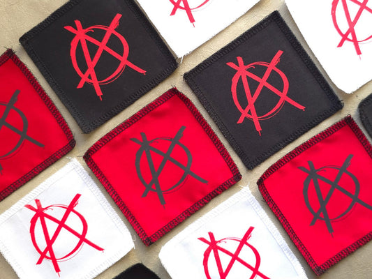Angled view of handmade screen printed anarchy symbol patch highlighting fabric texture and print detail