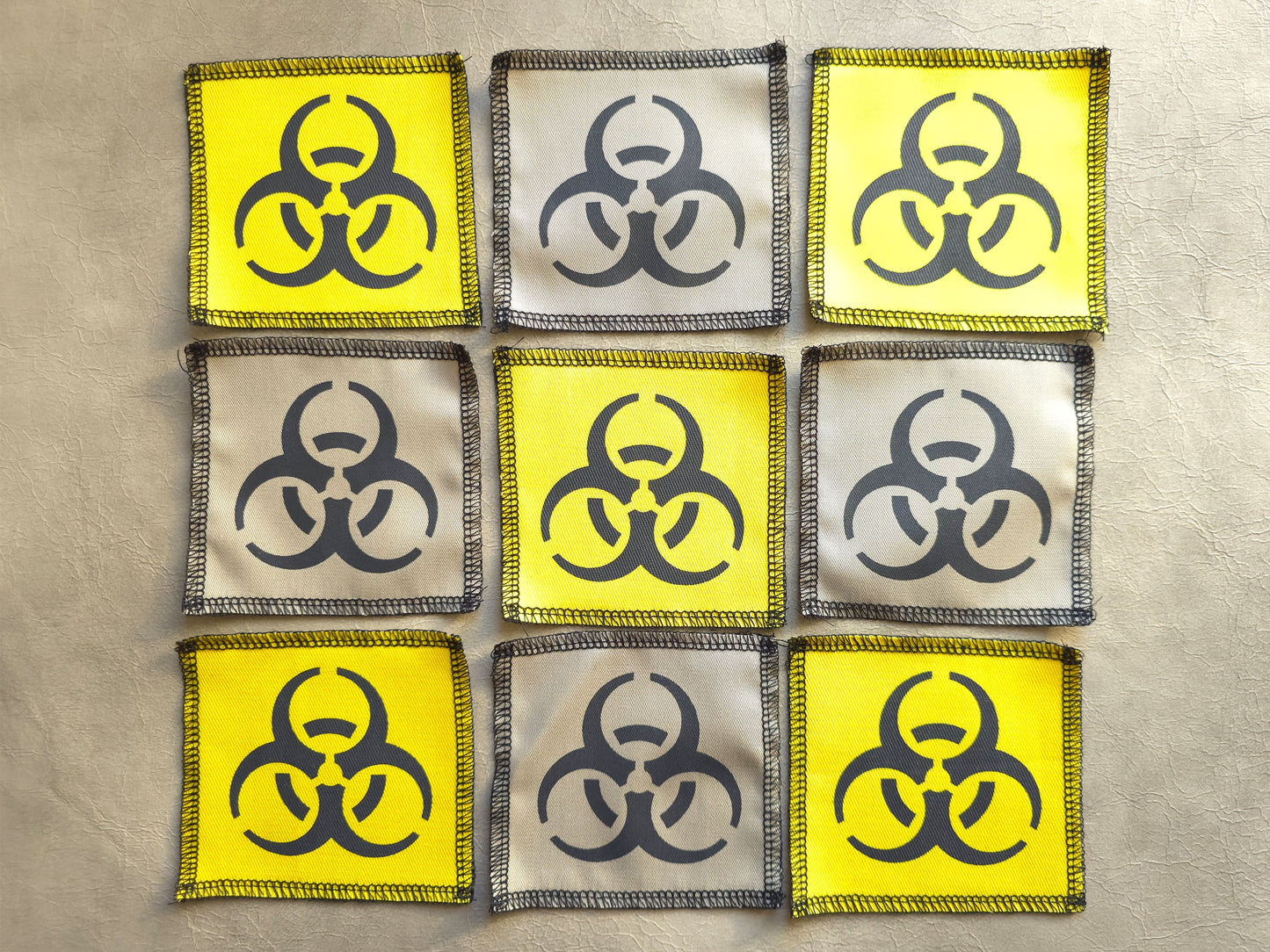 Assorted handmade screen printed biohazard symbol patches displayed together in different colors