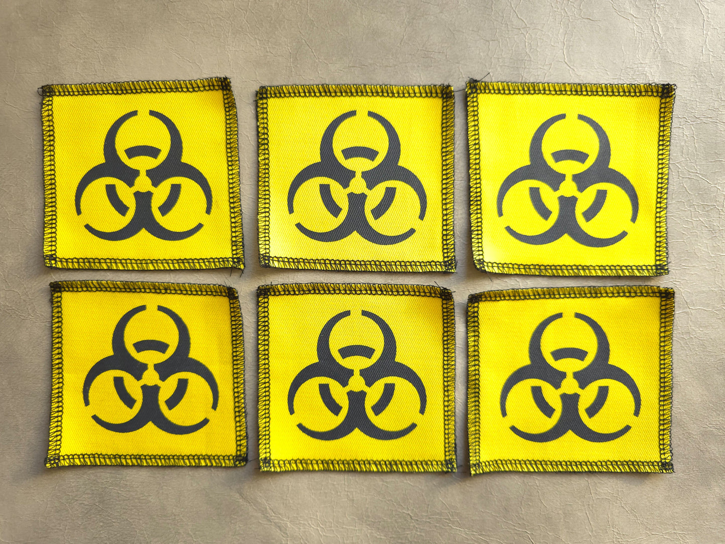 Set of yellow handmade screen printed biohazard symbol patches displayed together