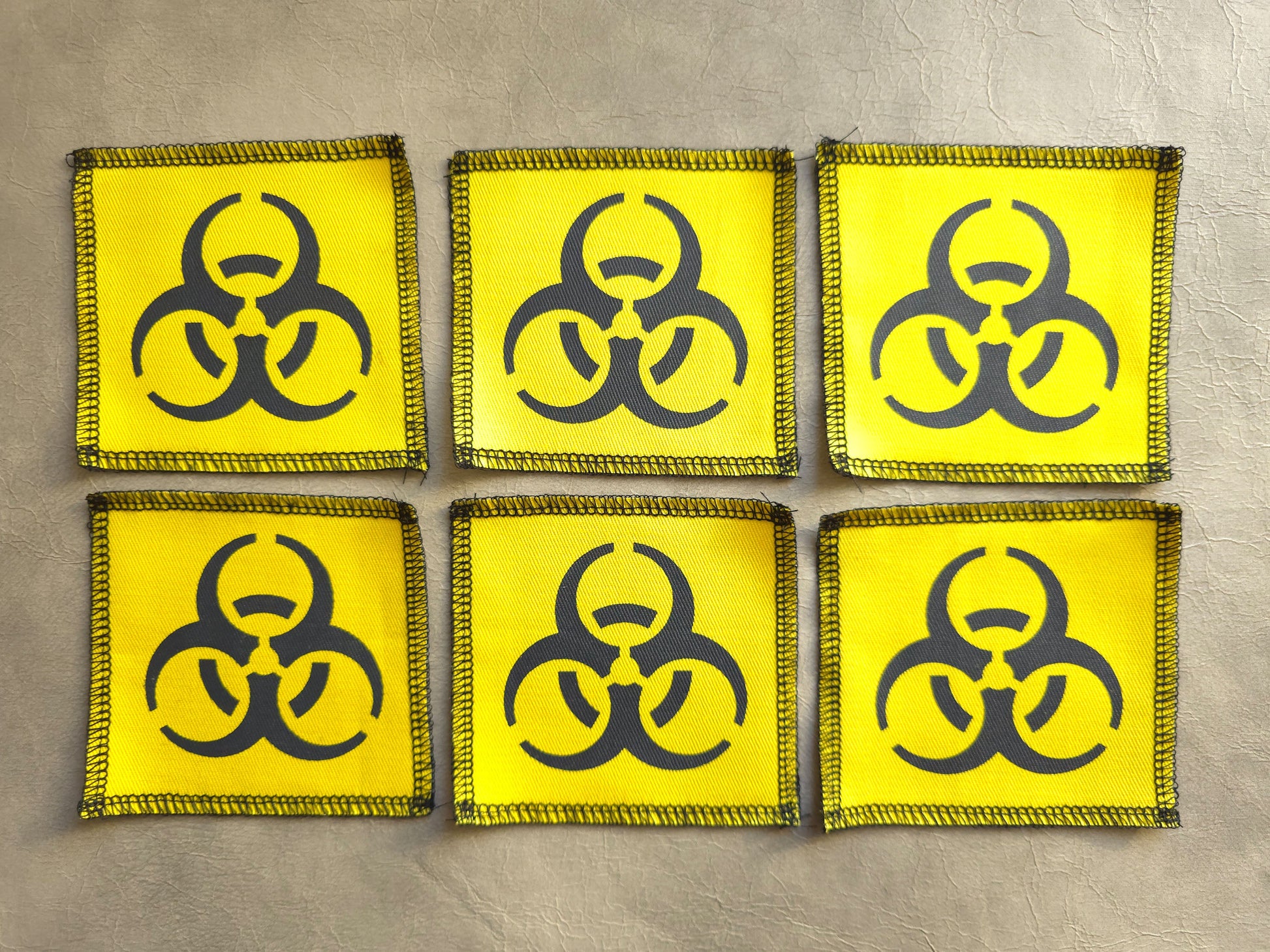 Set of yellow handmade screen printed biohazard symbol patches displayed together