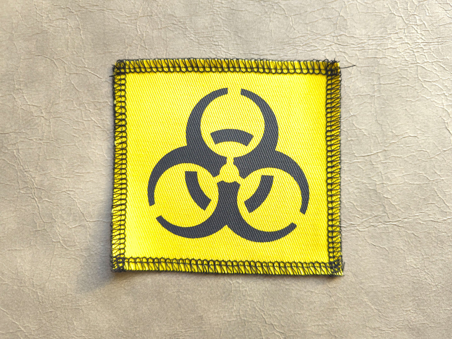Yellow handmade screen printed biohazard symbol patch with bold graphic print