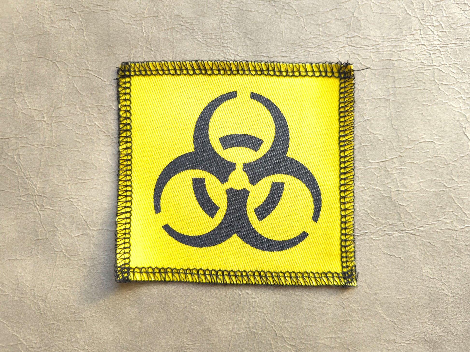 Yellow handmade screen printed biohazard symbol patch with bold graphic print