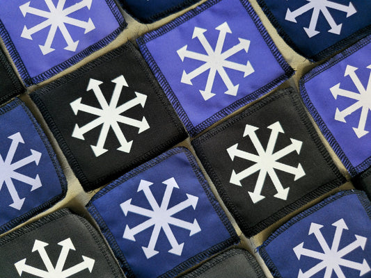 Angled view of handmade screen printed chaos symbol patch highlighting fabric texture and print detail