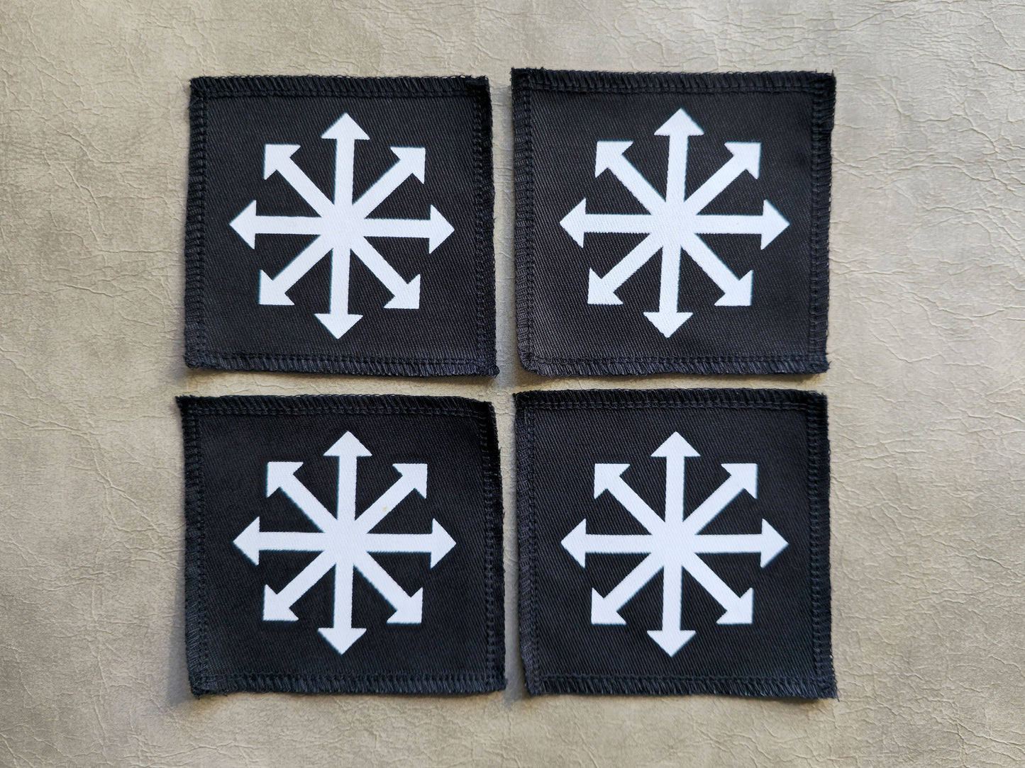 Black handmade screen printed chaos symbol patches displayed together