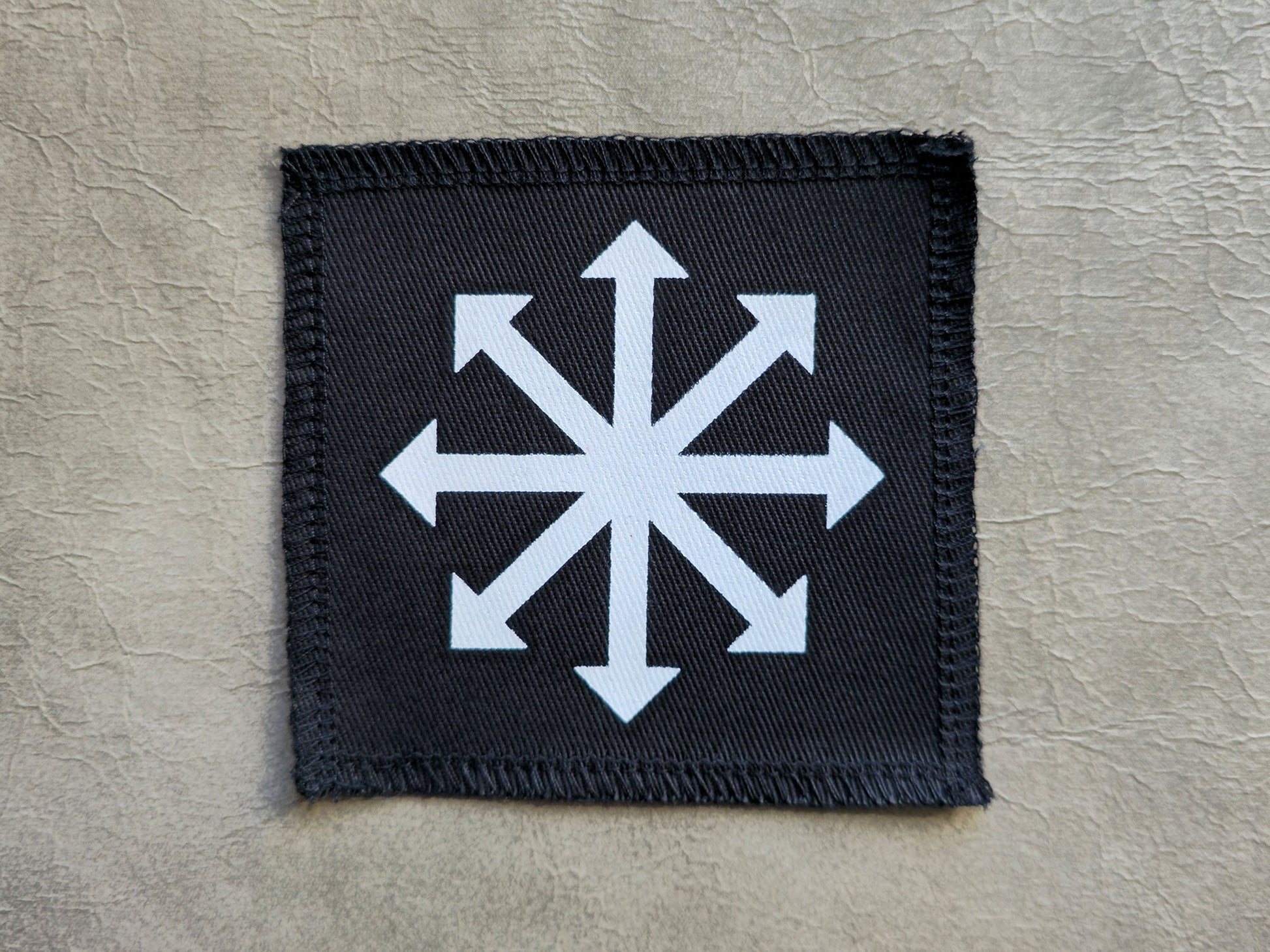 Black handmade screen printed chaos symbol patch with high-contrast printed graphic