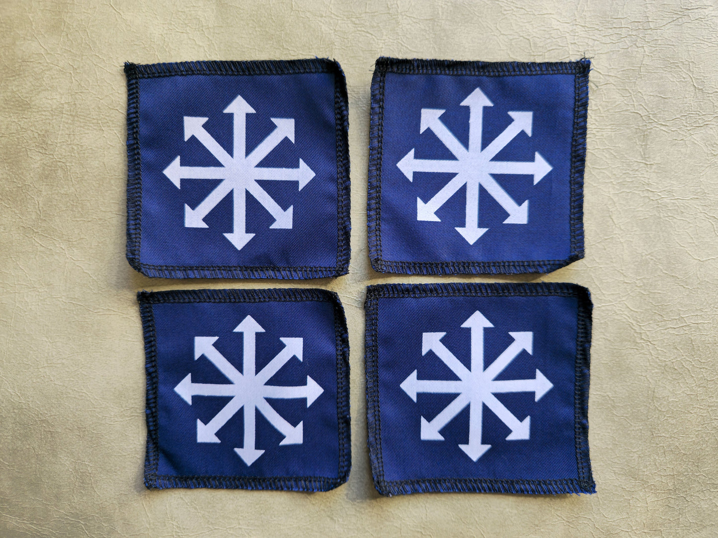 Blue handmade screen printed chaos symbol patches shown as a coordinated set