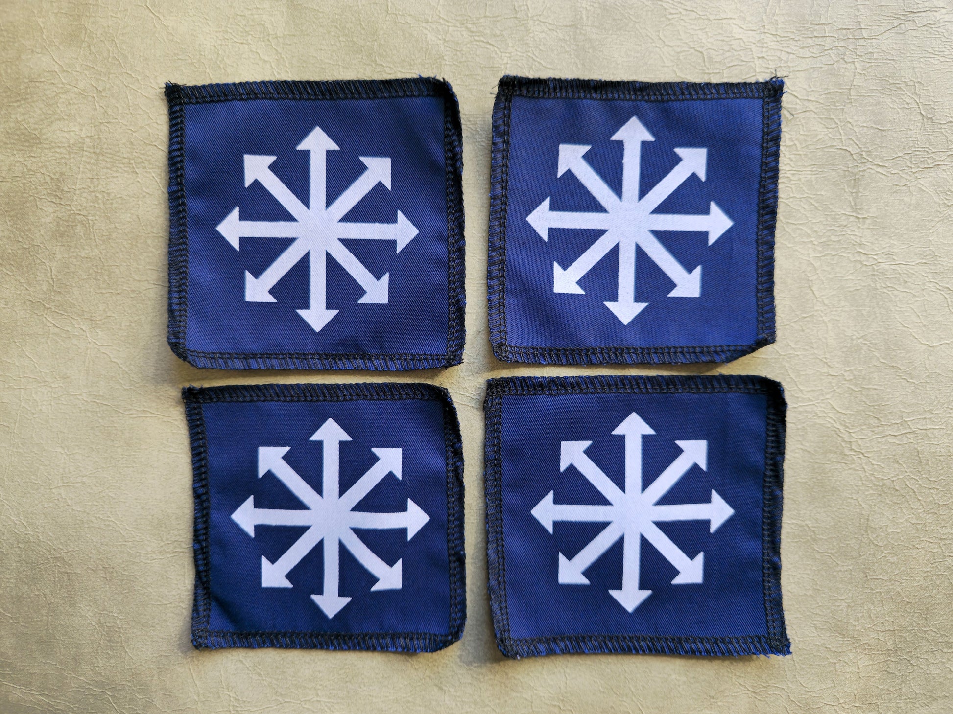 Blue handmade screen printed chaos symbol patches shown as a coordinated set