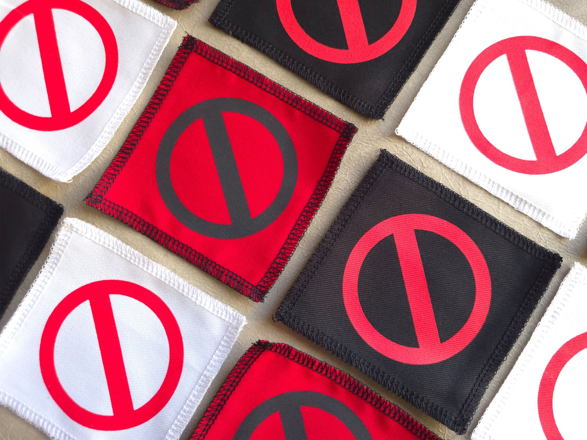 Angled view of handmade screen printed do not - crossed circle symbol patch highlighting fabric texture and print detail