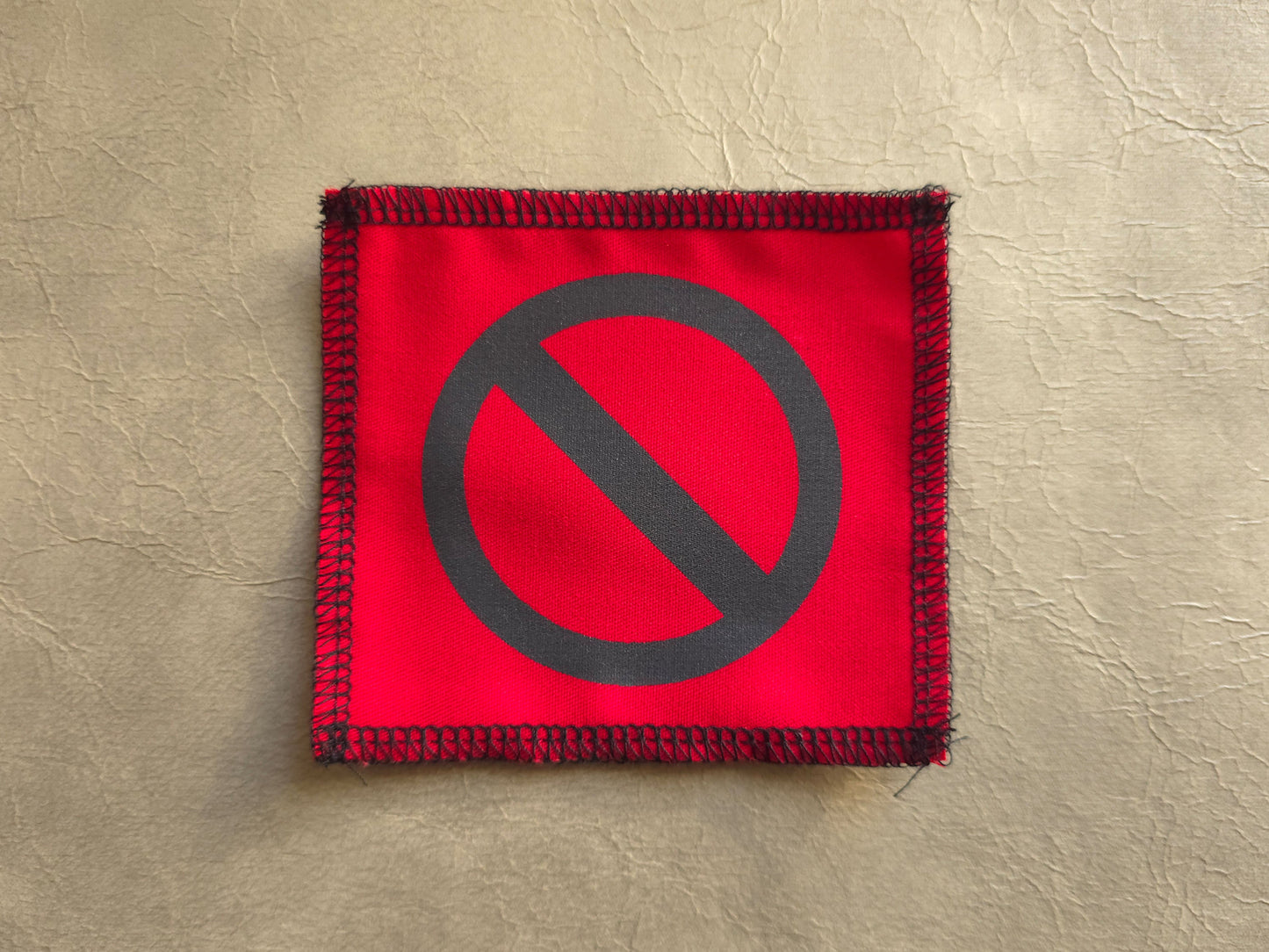 Red handmade screen printed do not symbol patch featuring bold printed symbol