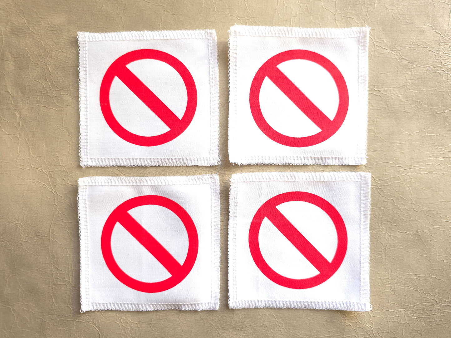 White handmade screen printed crossed circle symbol patches displayed as a set