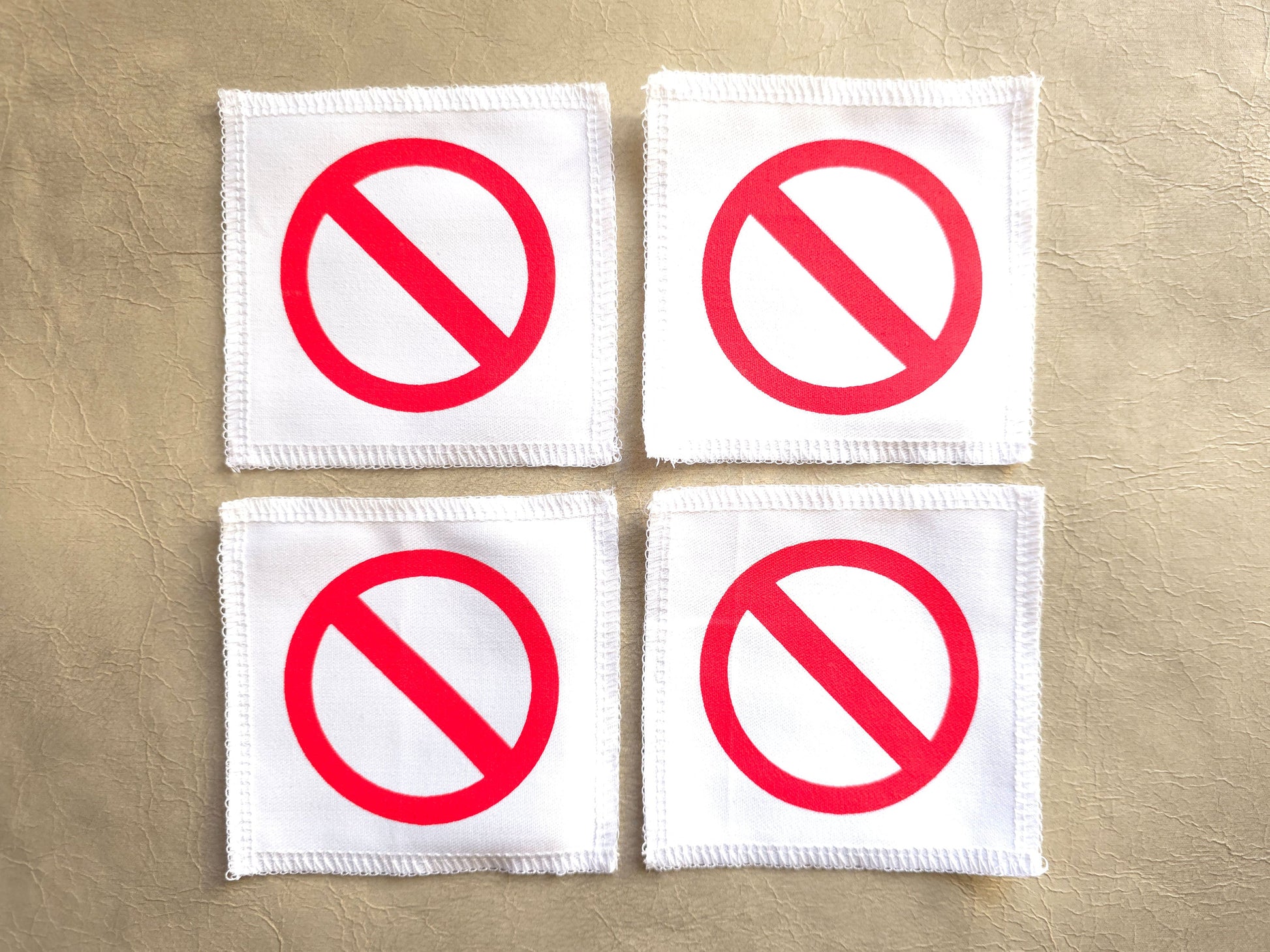 White handmade screen printed crossed circle symbol patches displayed as a set