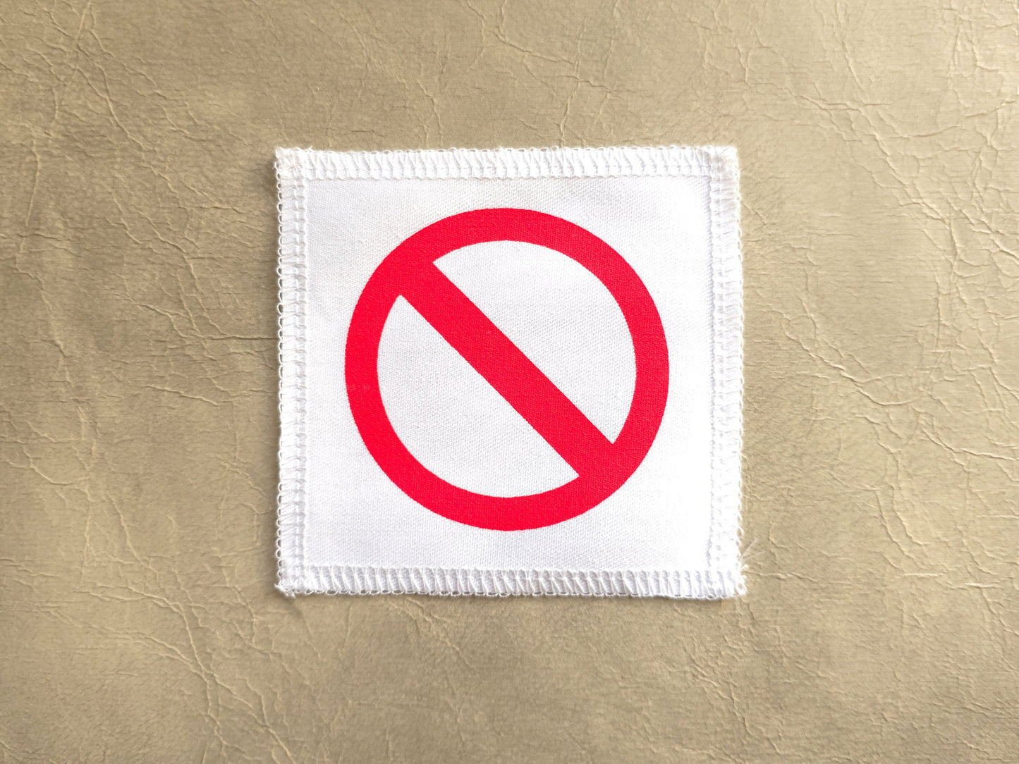 White handmade screen printed do not symbol patch with red printed design