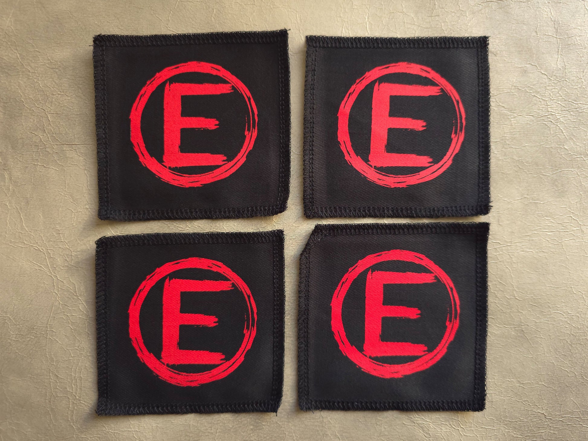 handmade screen printed black patches with red 'E' equality symbol