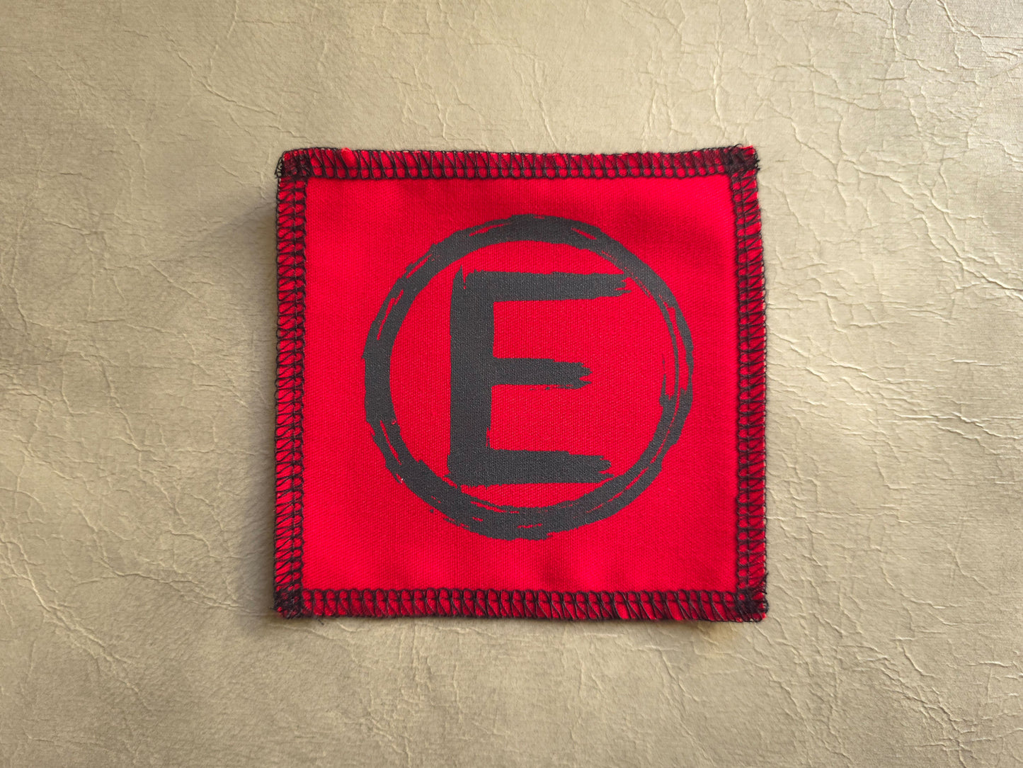 handmade screen printedRed square patch with a black letter 'E' - equality symbol