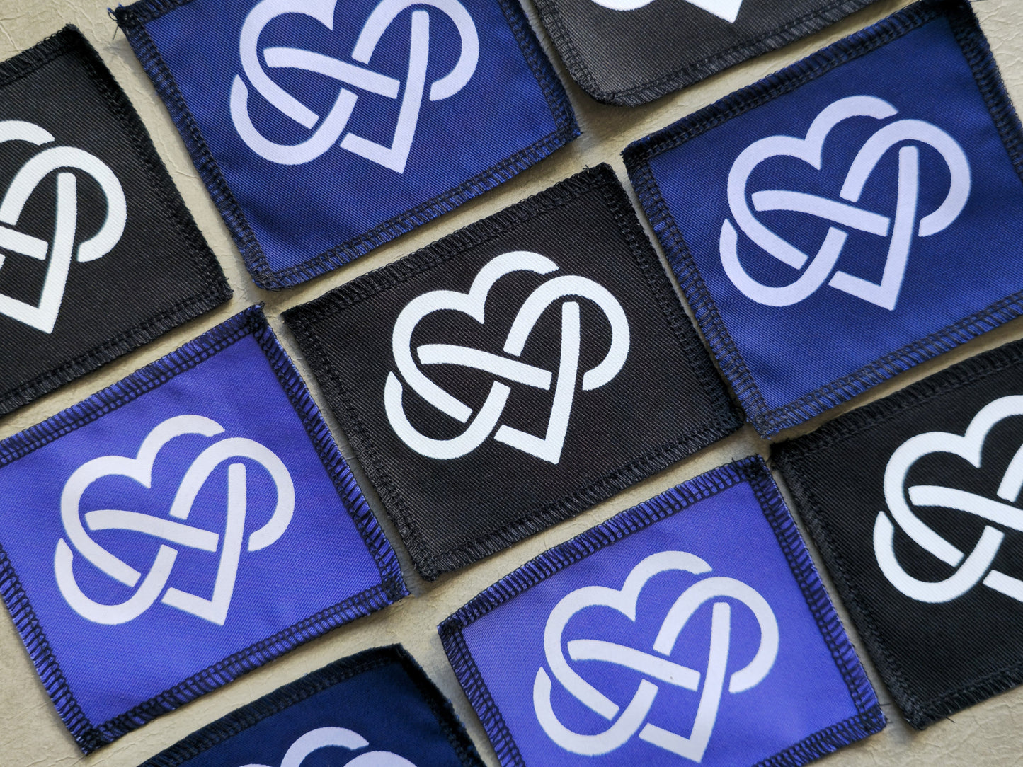 Angled view of handmade screen printed forever love symbol patch highlighting fabric texture and print detail