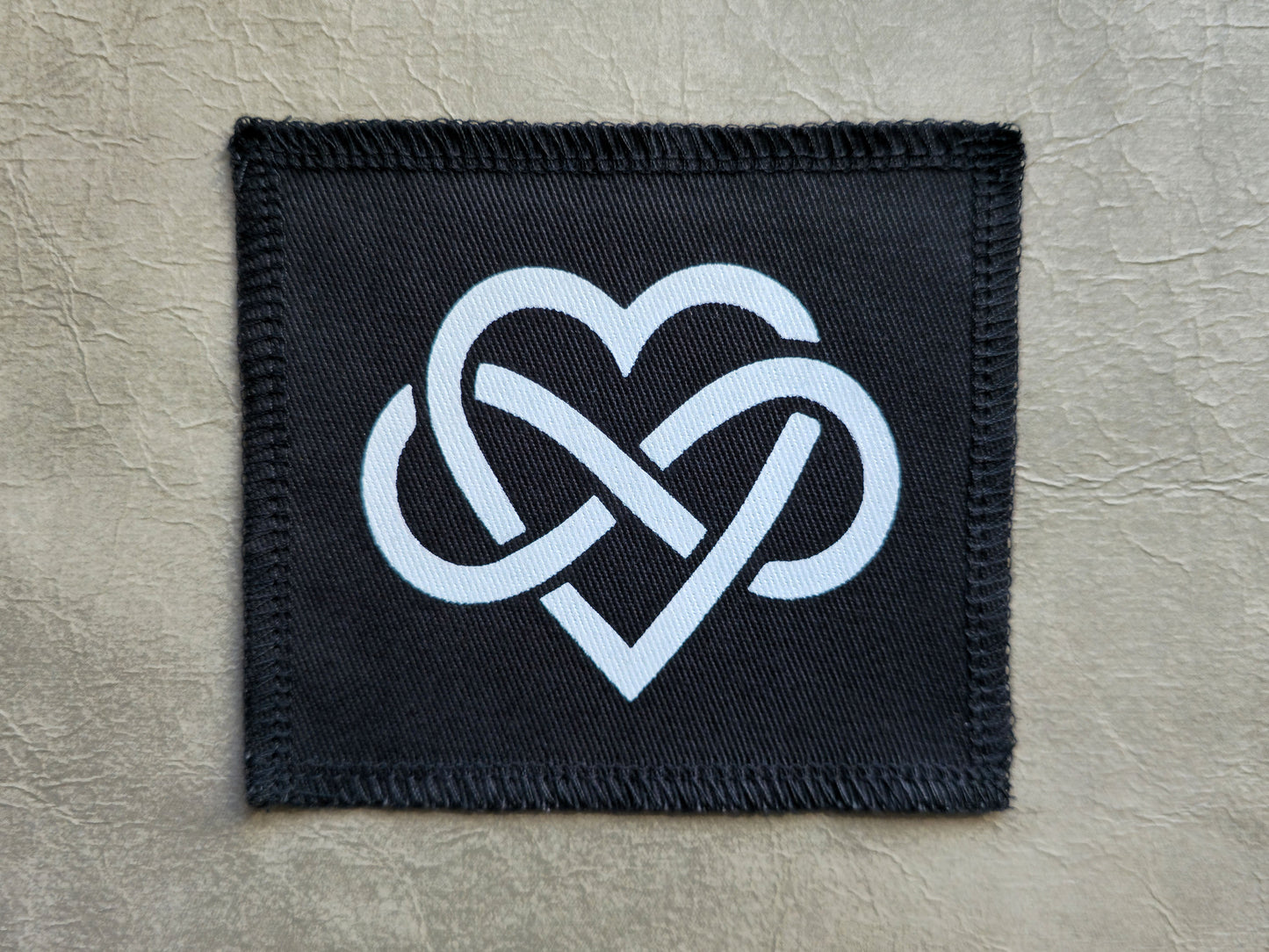 Black handmade screen printed forever love symbol patch with high-contrast printed graphic