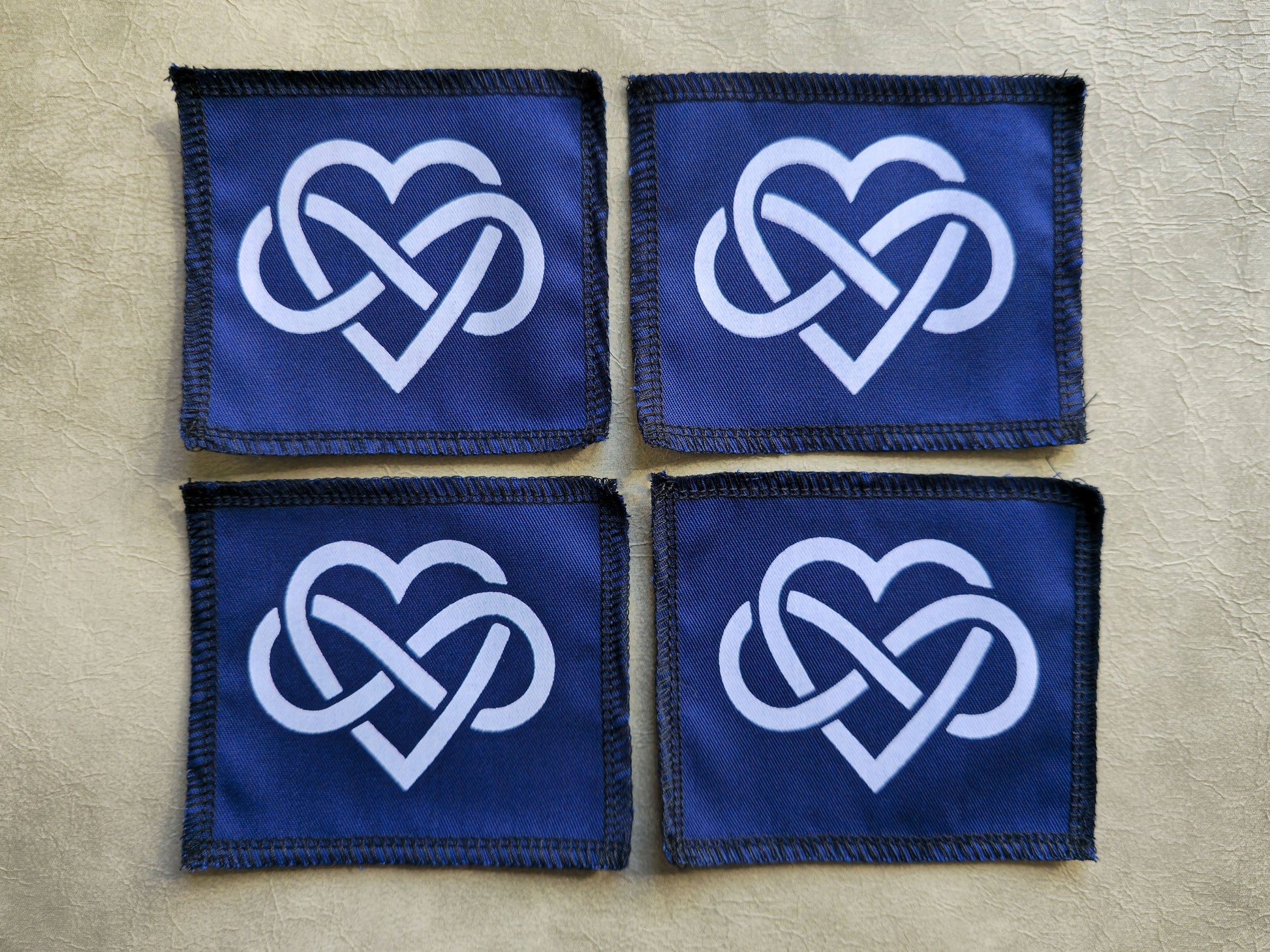 Blue handmade screen printed forever love symbol patches shown as a coordinated set