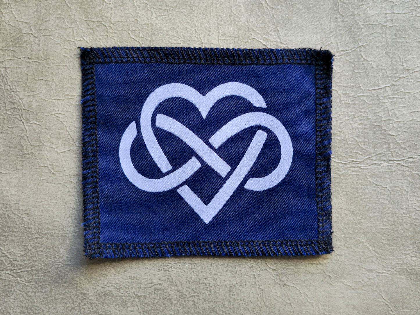 Blue handmade screen printed forever love symbol patch with contrasting ink detail