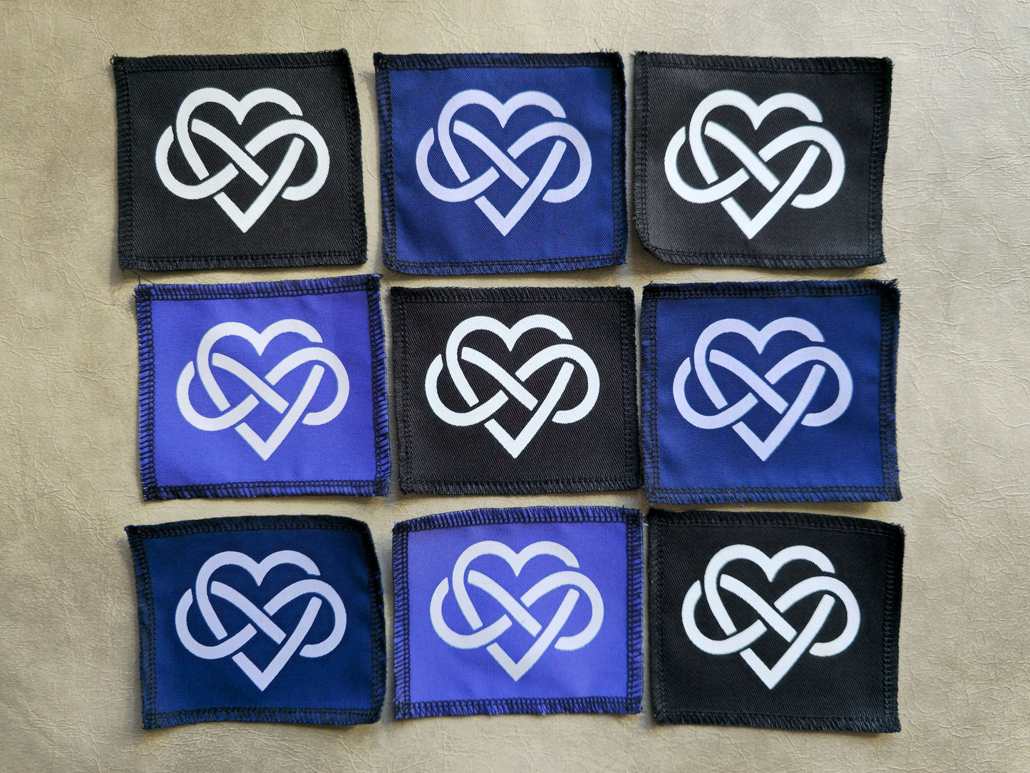 Assorted handmade screen printed forever love symbol patches displayed together in different colors