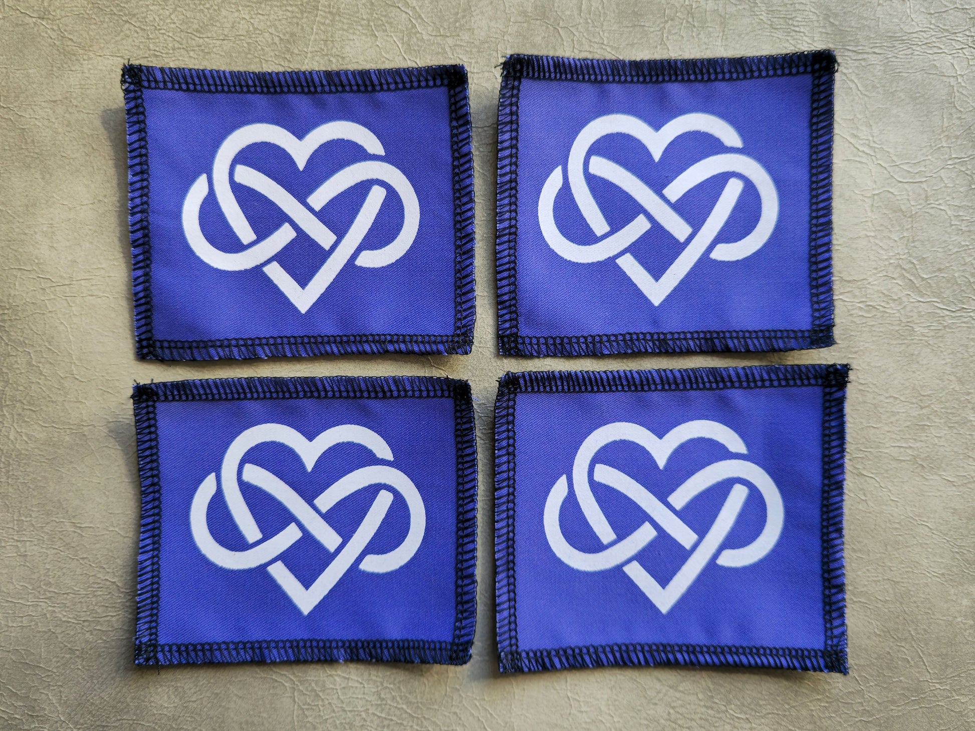 Purple handmade screen printed forever love symbol patches shown together