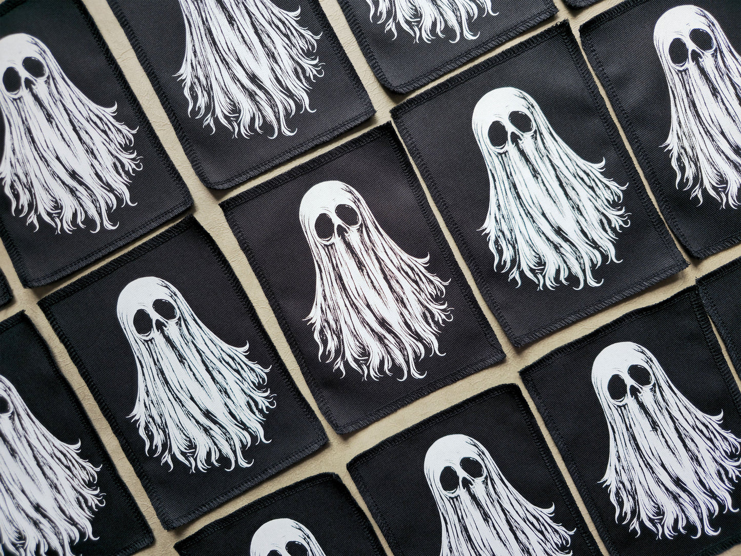 Angled view of handmade screen printed ghost patches showing texture, stitching, and vibrant print details