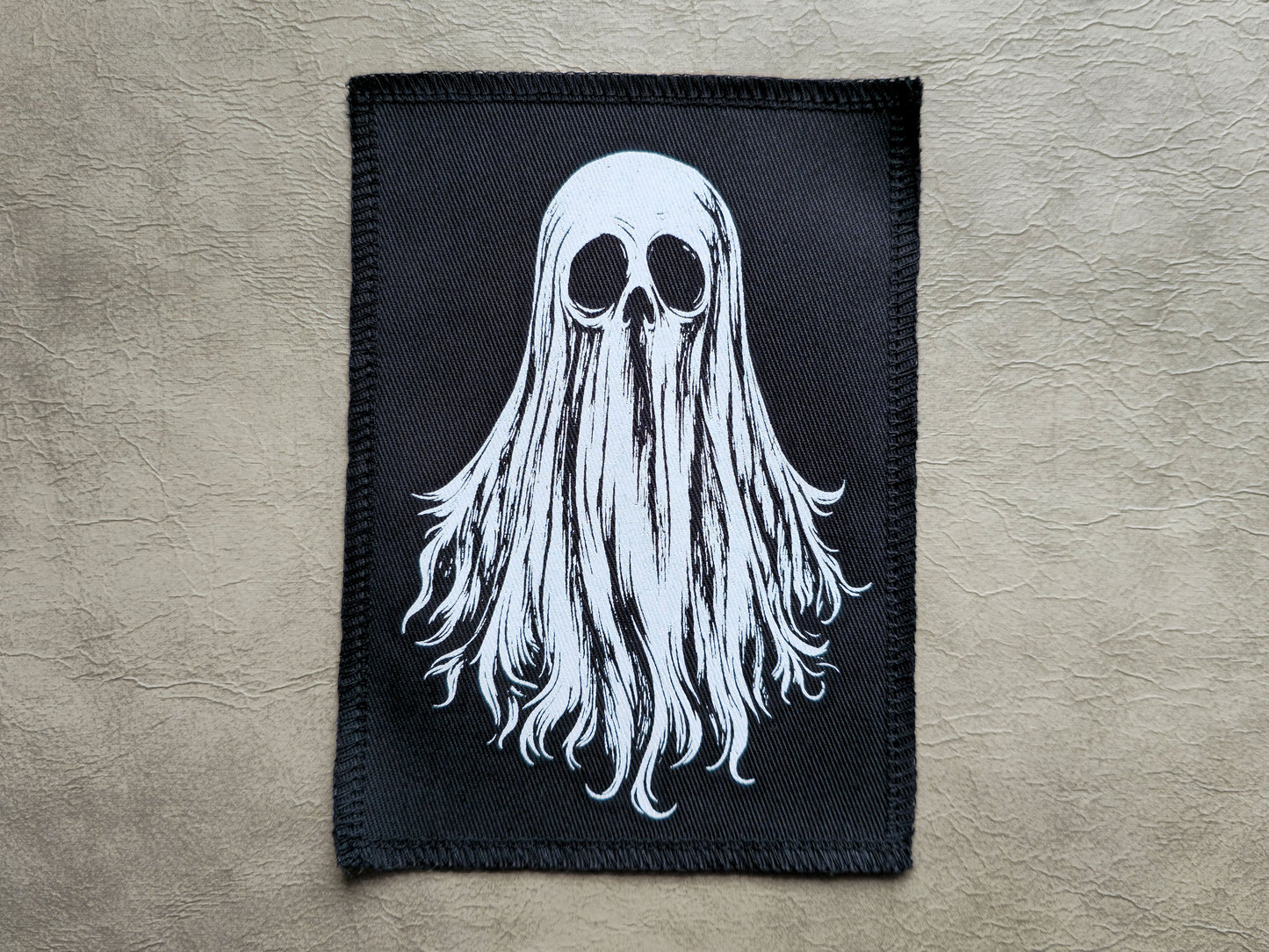 Front view of a handmade screen printed ghost patch with bold ink design on durable fabric backing