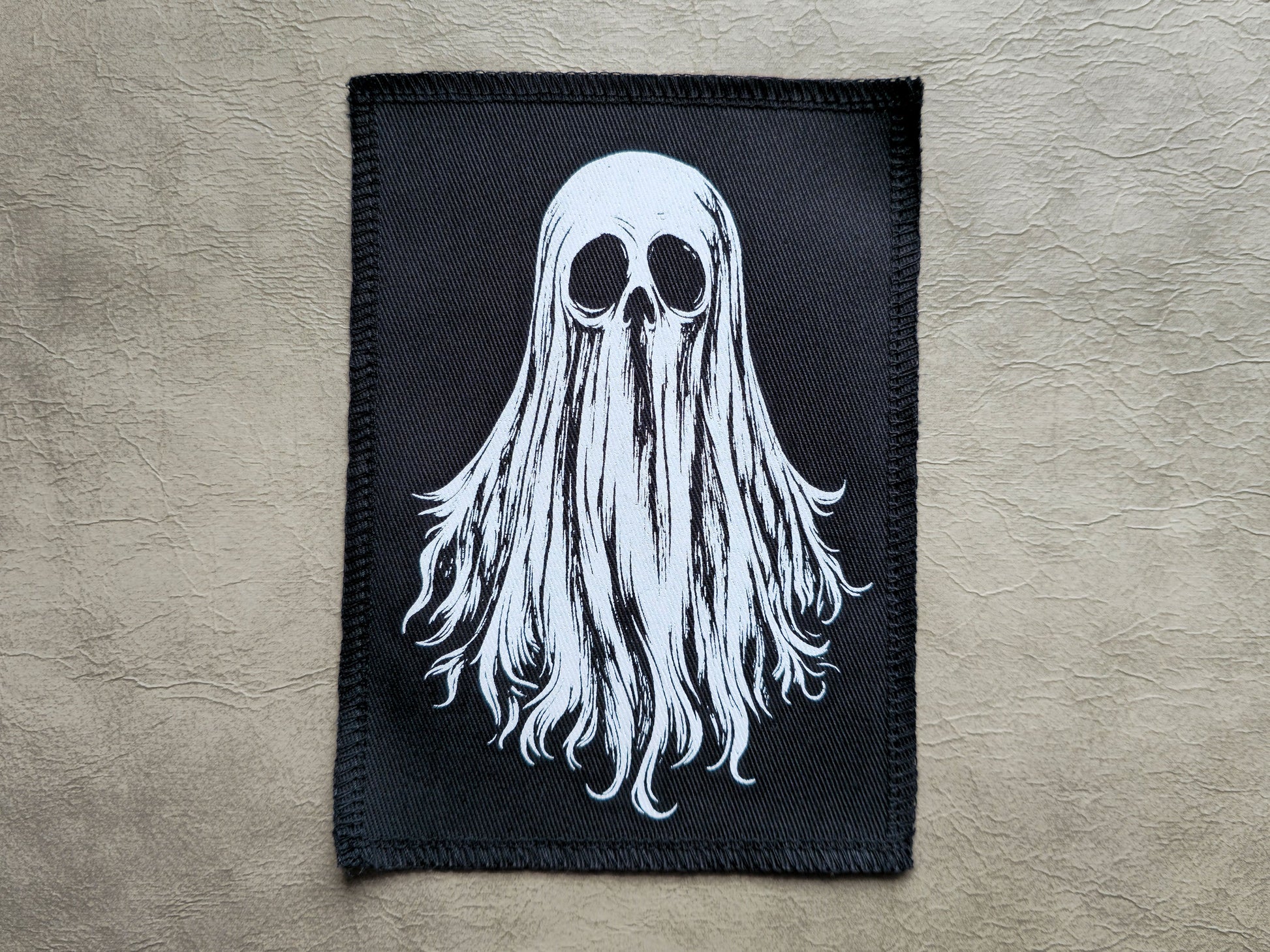 Front view of a handmade screen printed ghost patch with bold ink design on durable fabric backing