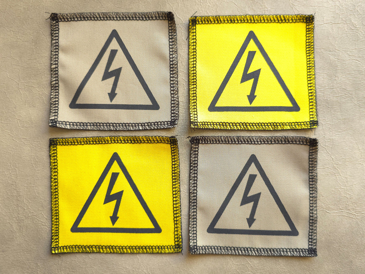 Handmade screen printed high voltage symbol patch, front view showing detailed ink design on fabric