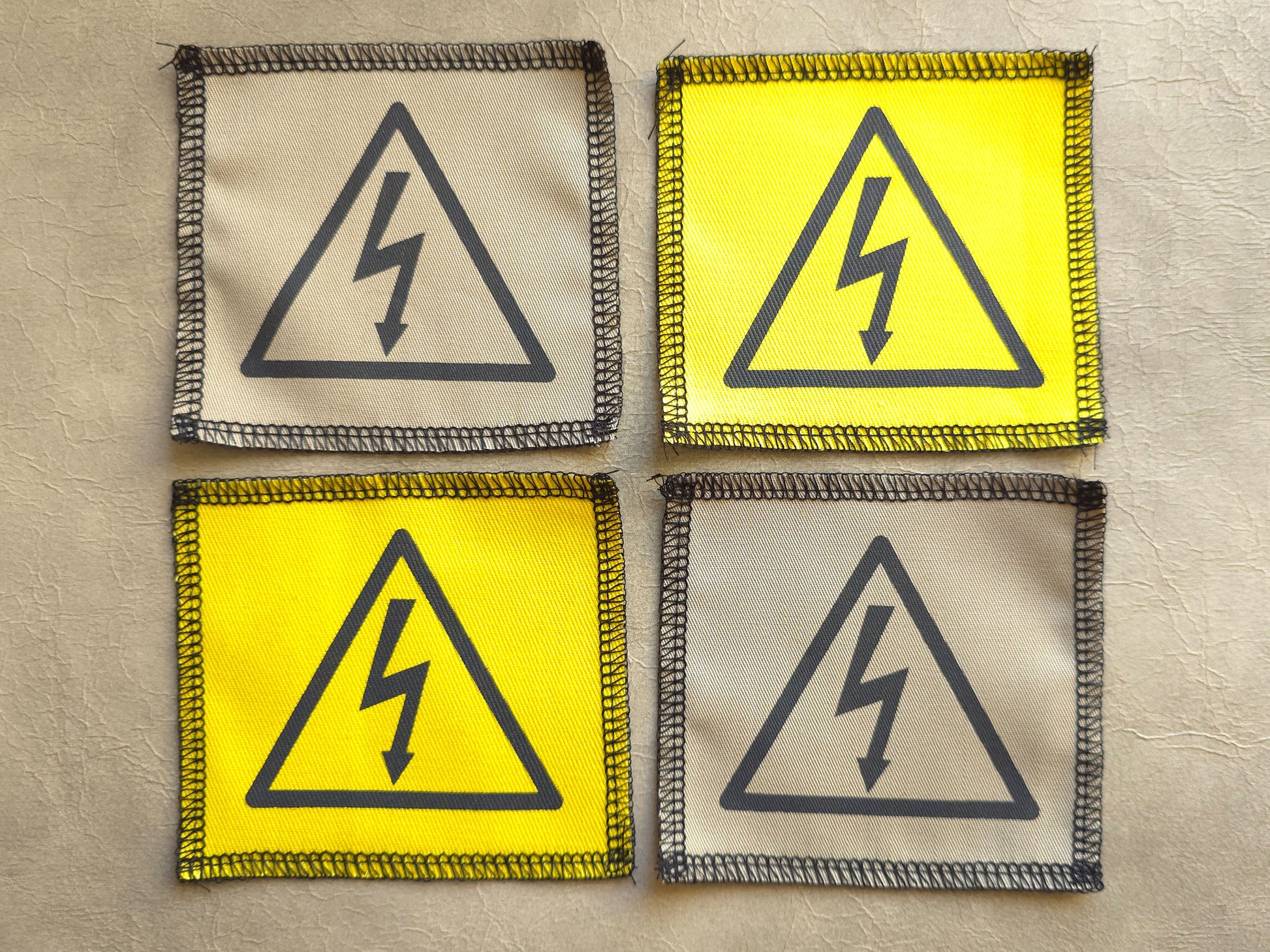 Handmade screen printed high voltage symbol patch, front view showing detailed ink design on fabric
