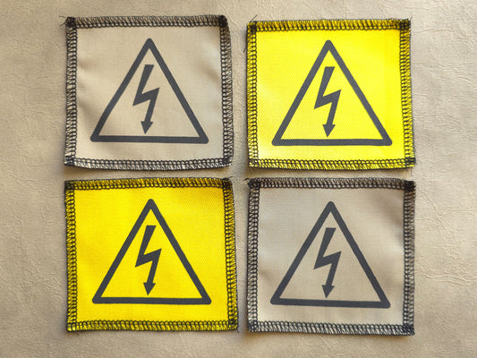 Handmade screen printed high voltage symbol patch, front view showing detailed ink design on fabric