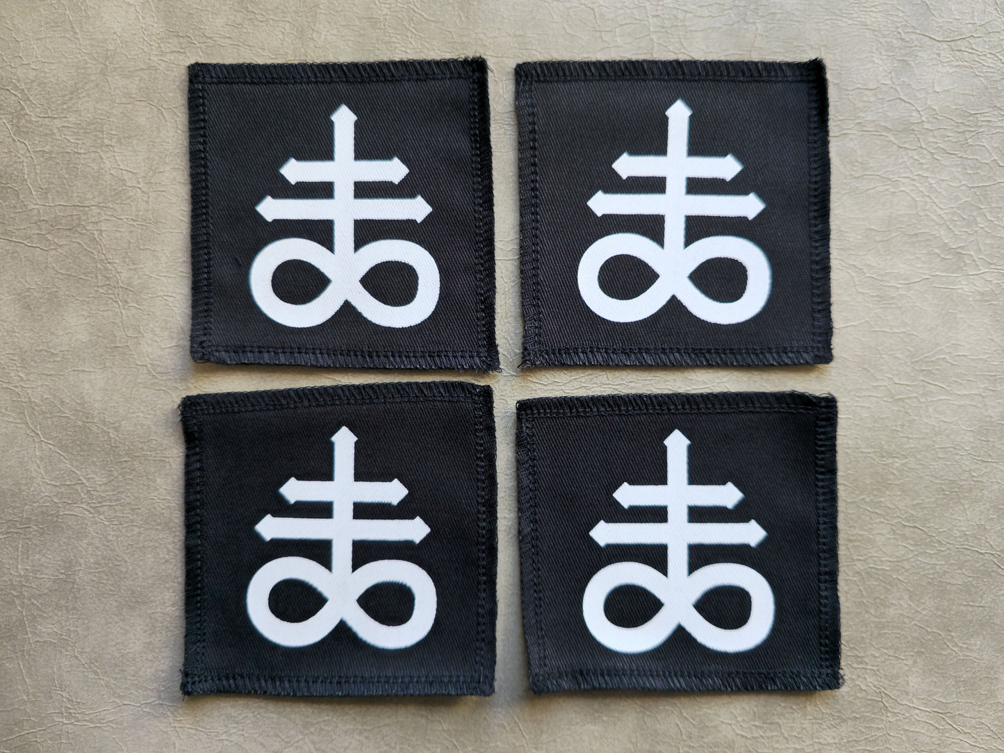 Black handmade screen printed leviathan symbol patches displayed together