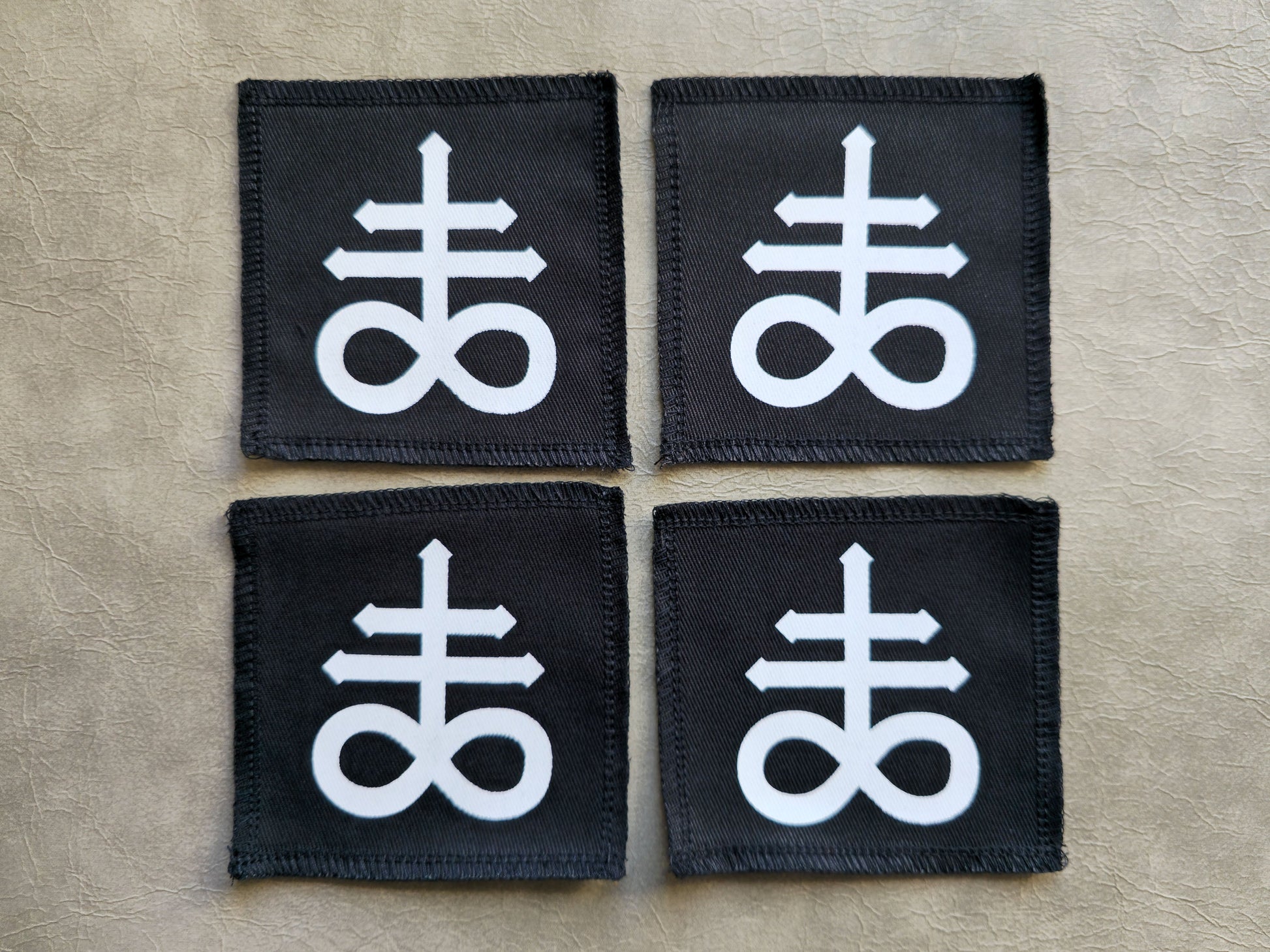 Black handmade screen printed leviathan symbol patches displayed together