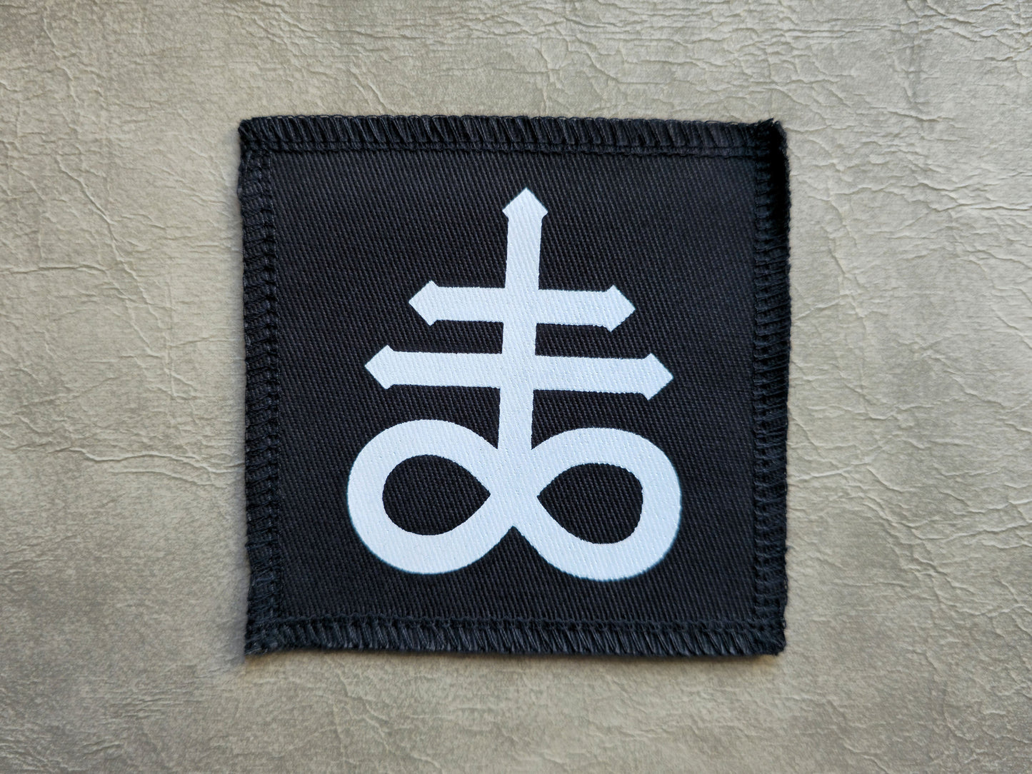 Black handmade screen printed leviathan symbol patch with high-contrast printed graphic