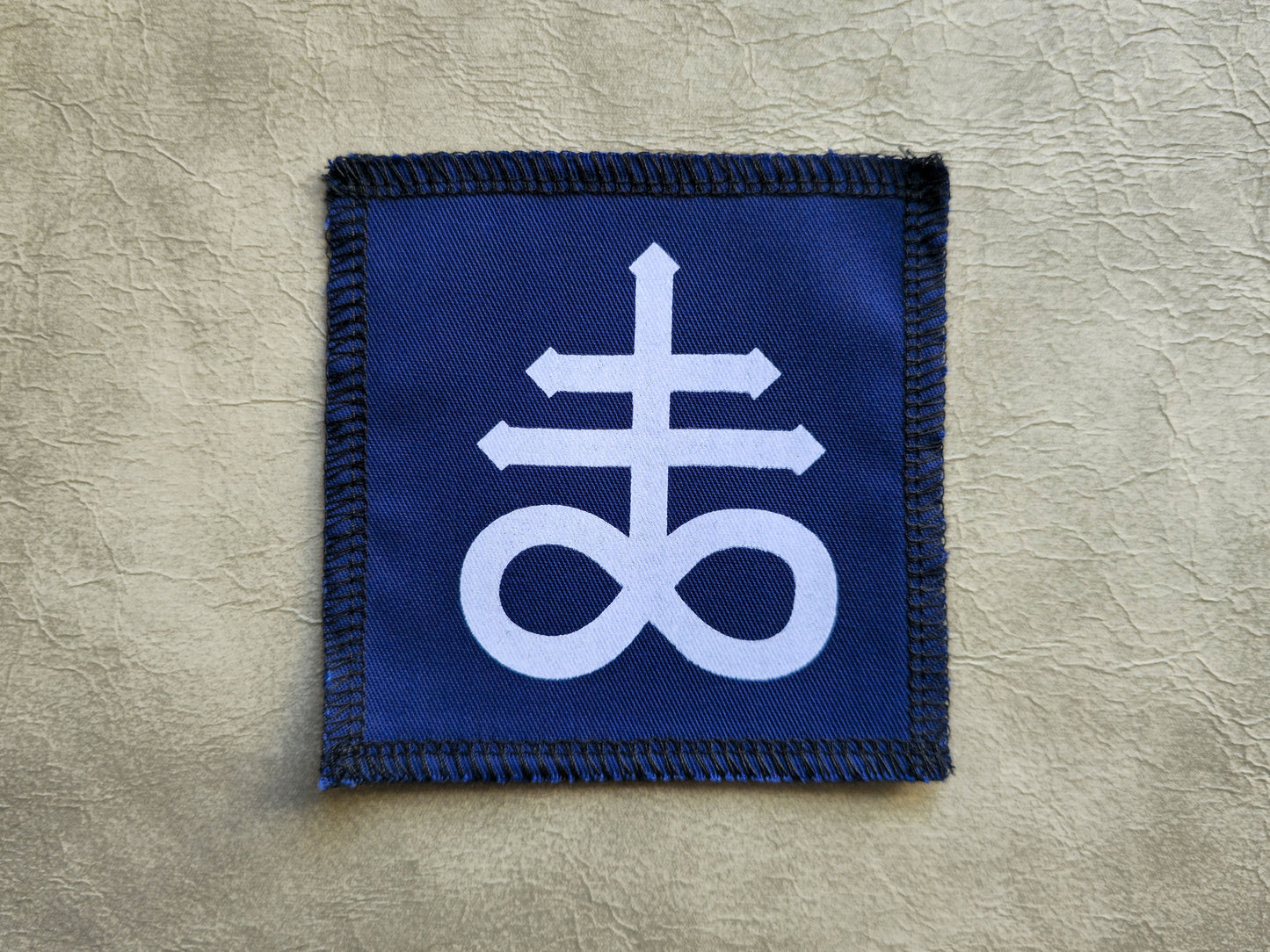 Blue handmade screen printed leviathan symbol patch with contrasting ink detail