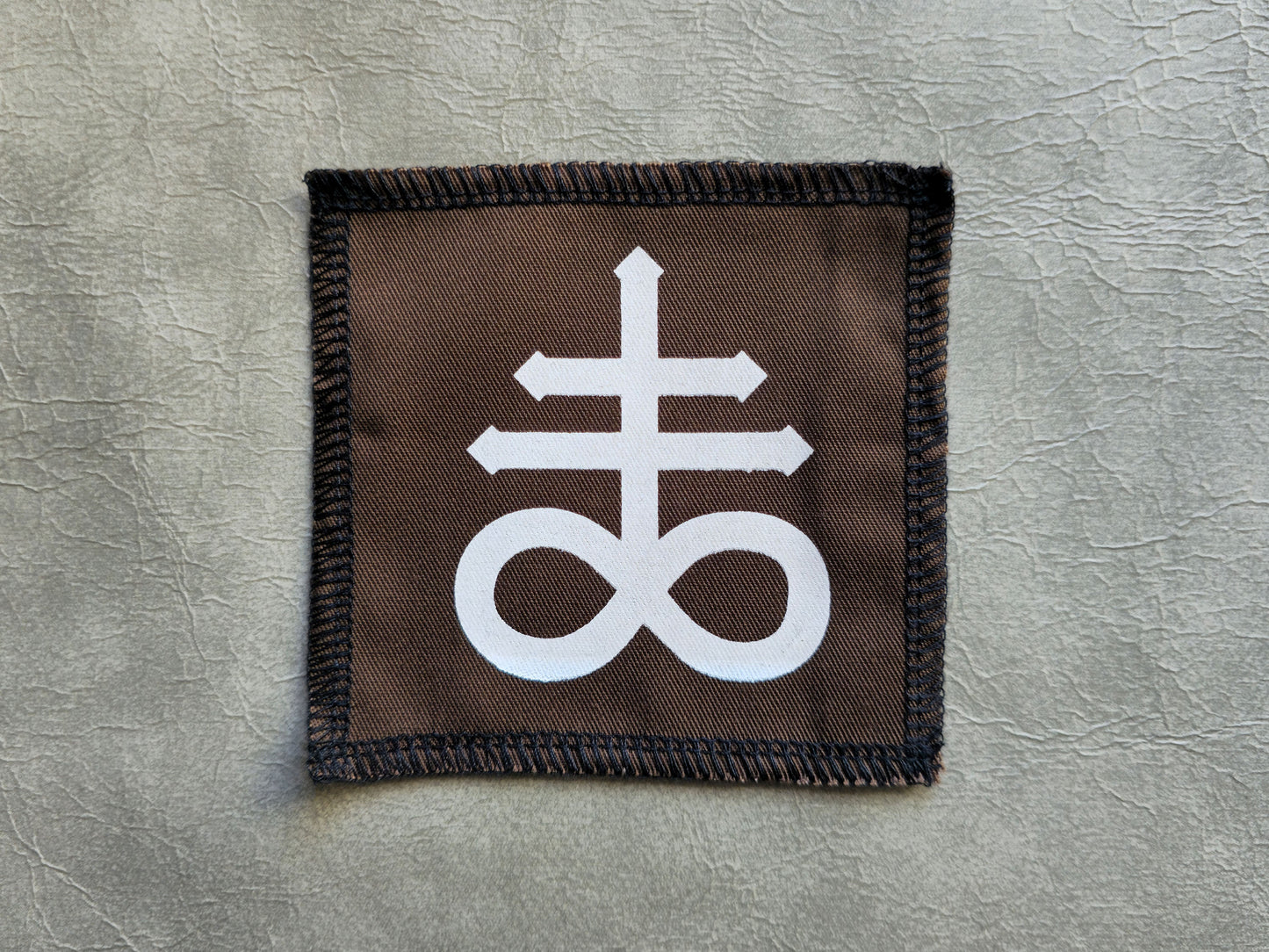 Brown handmade screen printed leviathan symbol patch with centered graphic print