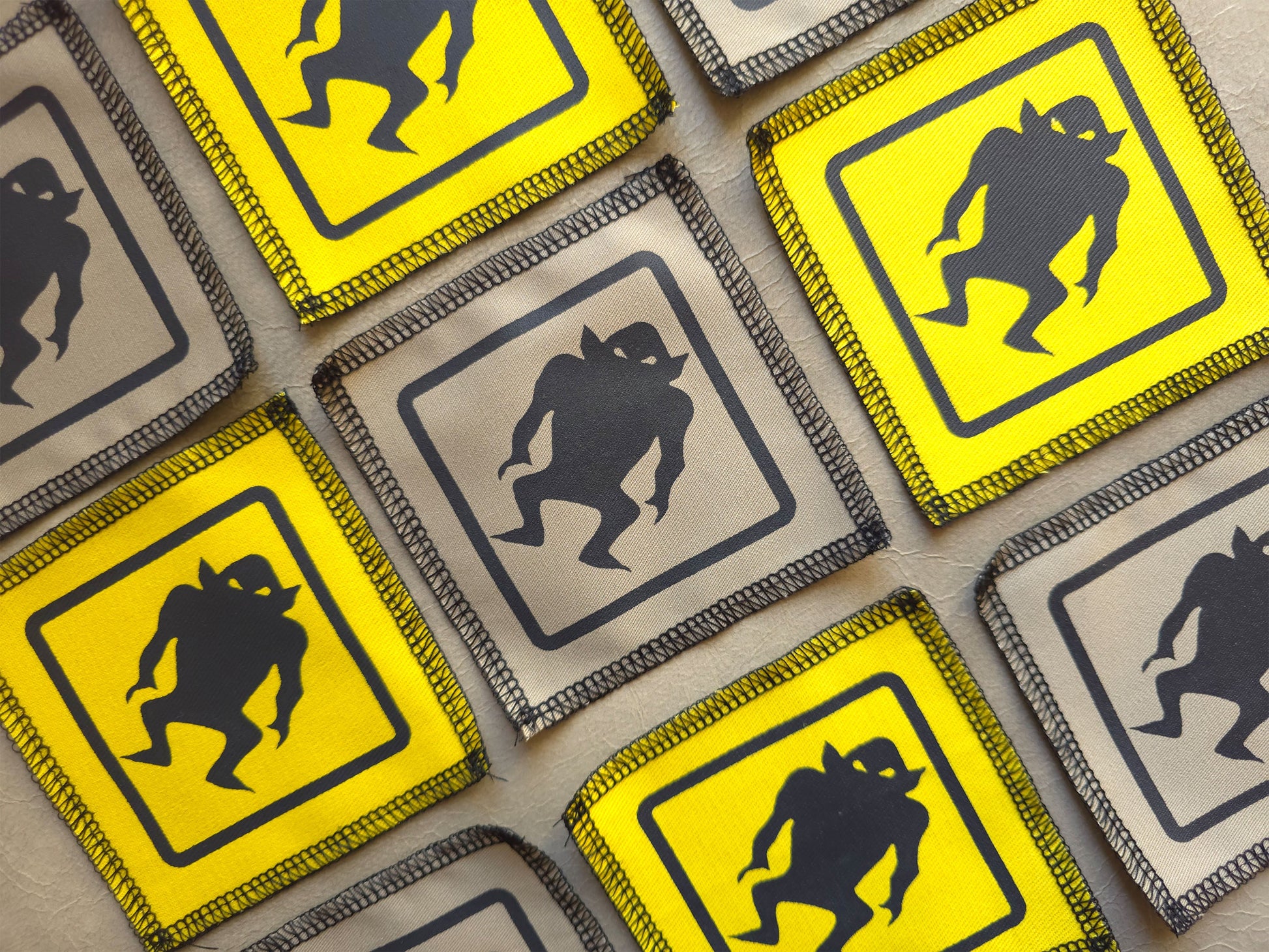 Handmade screen printed monster warning signs in a yellow and black design