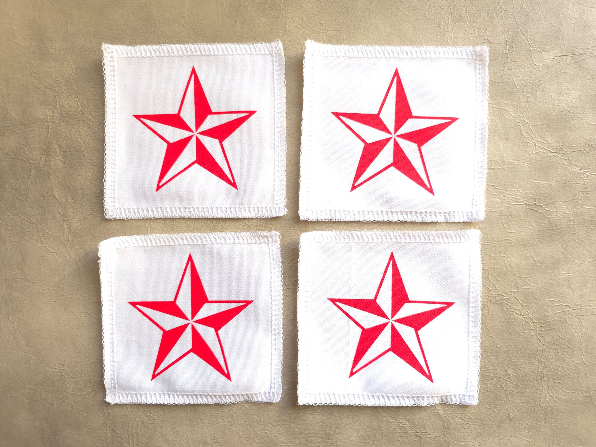 handmade screen printed Four white patches with red stars on a beige background