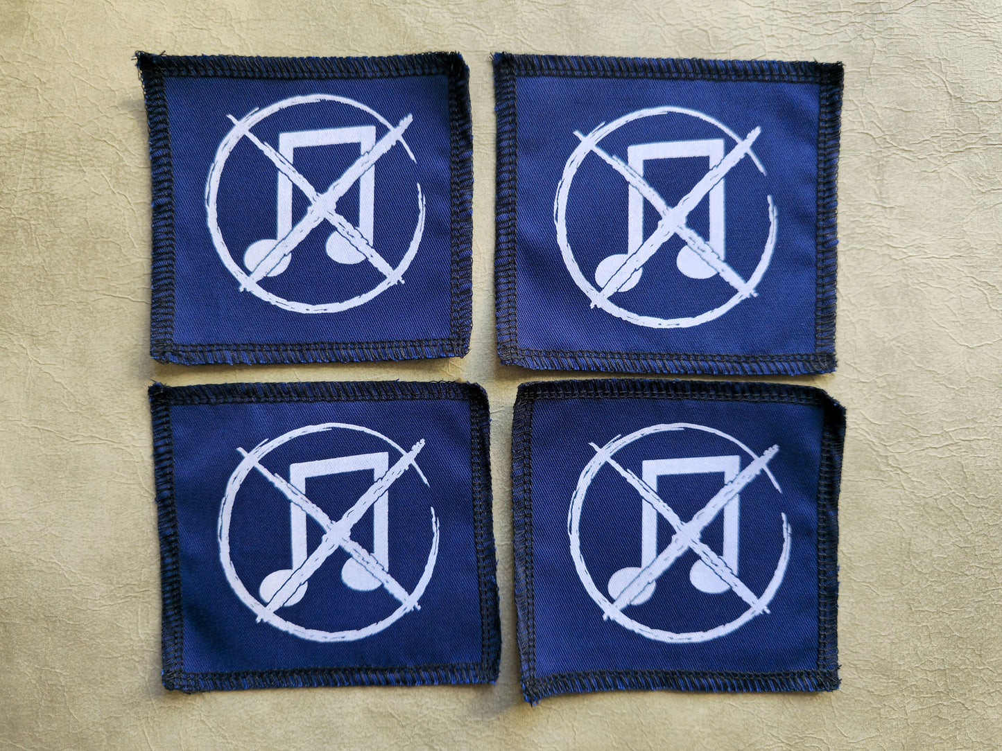 Blue handmade screen printed noise not music symbol patches shown as a coordinated set