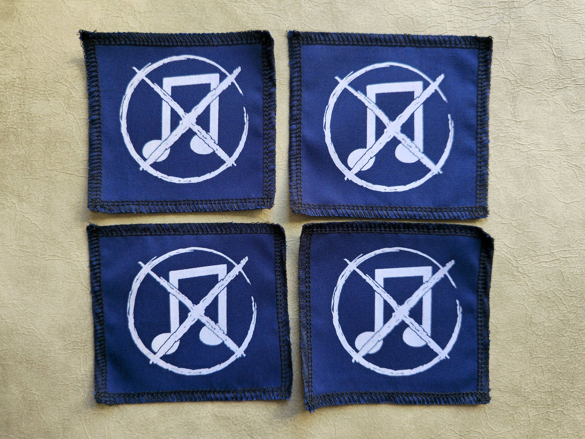 Blue handmade screen printed noise not music symbol patches shown as a coordinated set