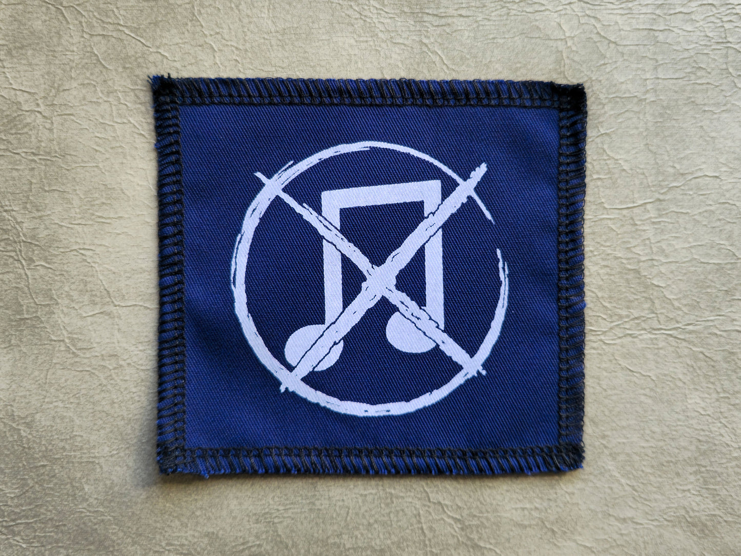 Blue handmade screen printed noise not music symbol patch with contrasting ink detail