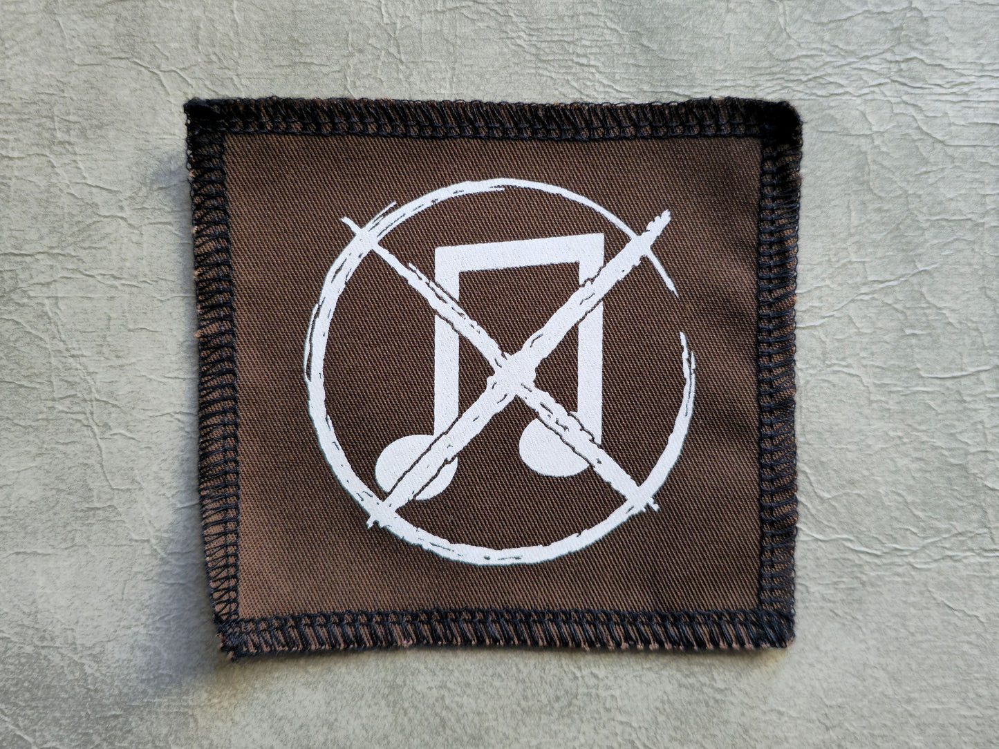 Brown handmade screen printed noise not music symbol patch with centered graphic print
