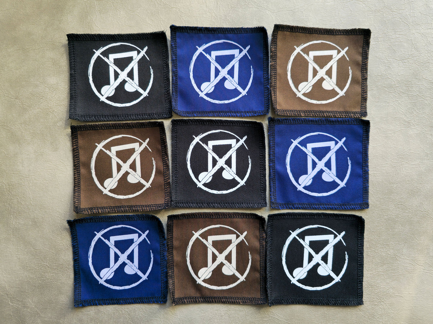 Assorted handmade screen printed noise not music symbol patches displayed together in different colors
