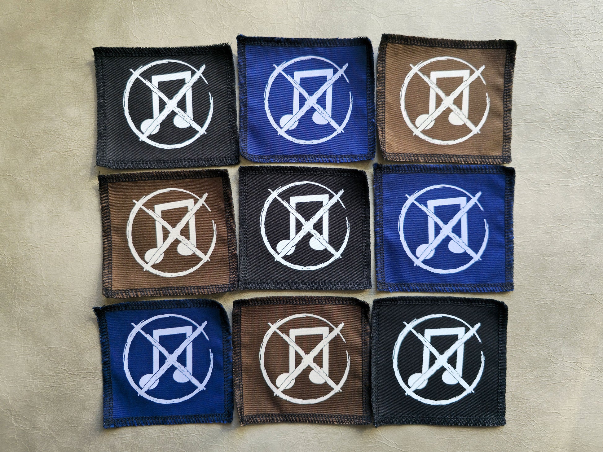 Assorted handmade screen printed noise not music symbol patches displayed together in different colors