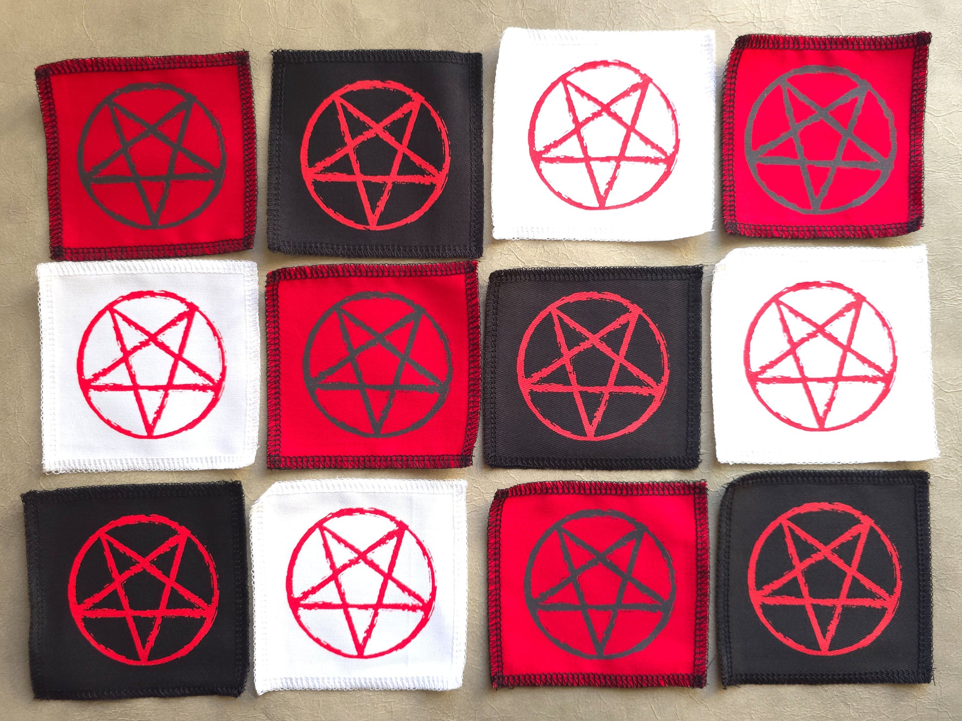 handmade screen printed patches with red and black pentagram designs 