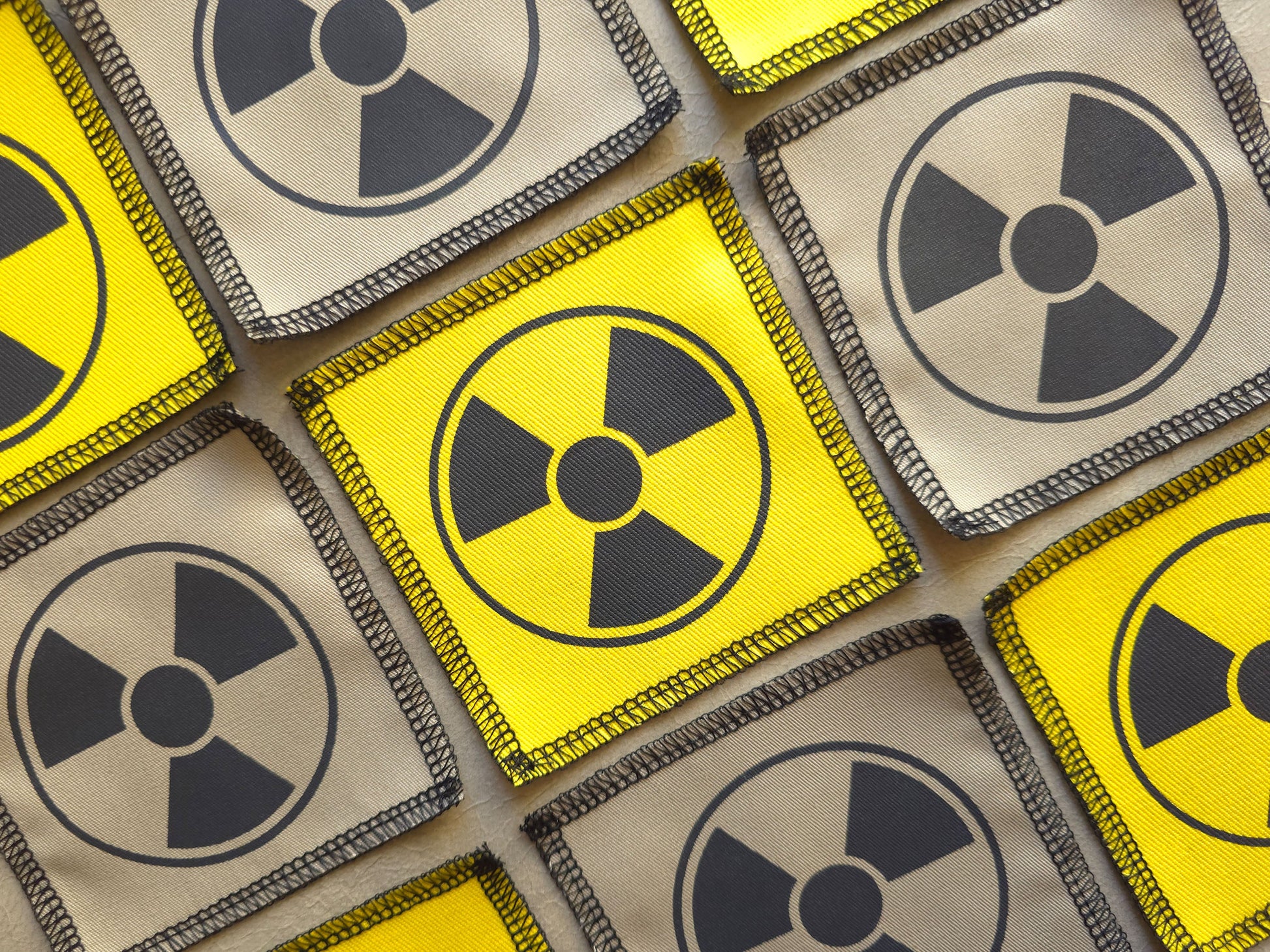 Angled view of handmade screen printed radioactive symbol patch highlighting fabric texture and print detail