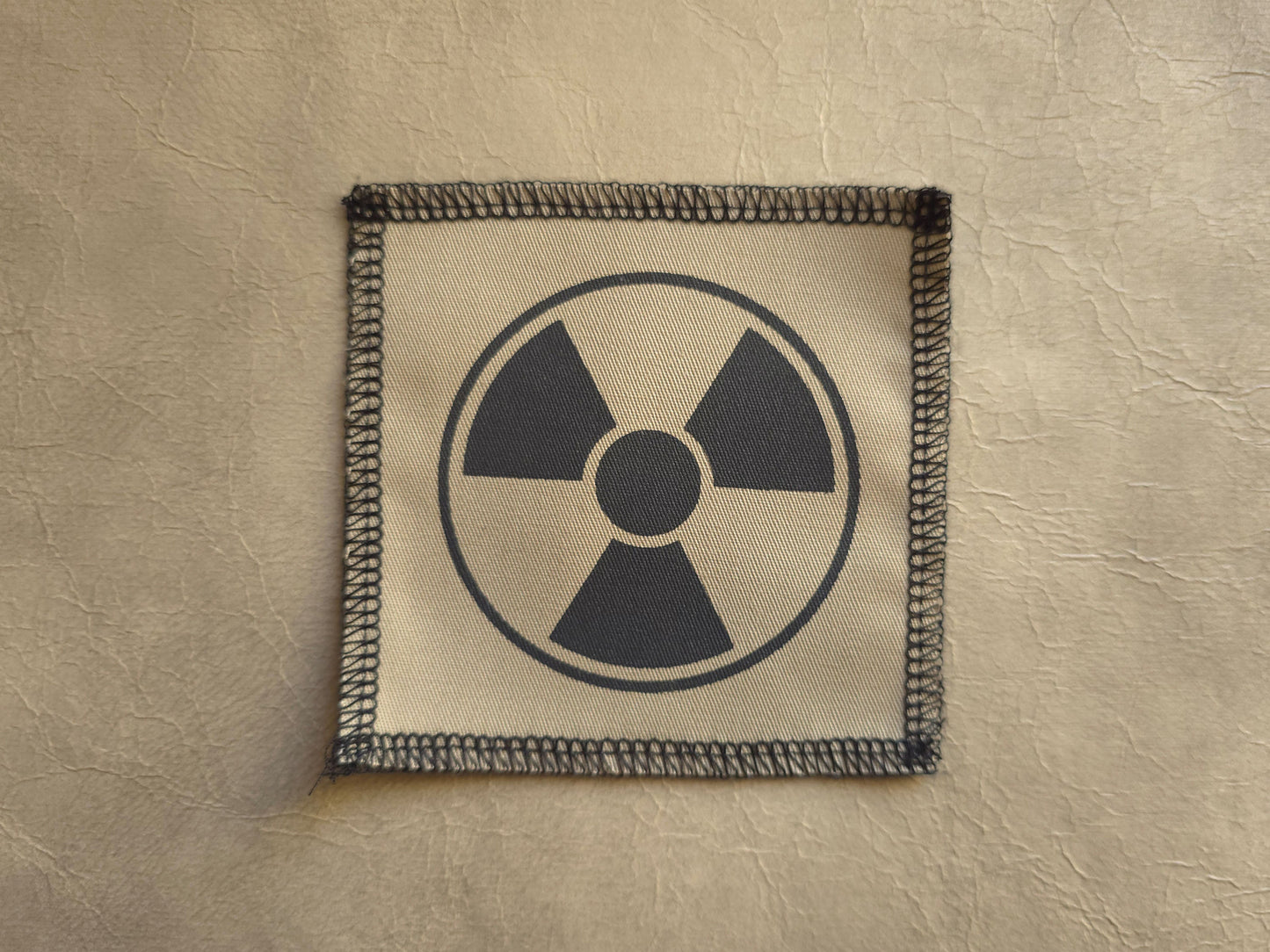 Beige handmade screen printed radioactive symbol patch with clean printed symbol design