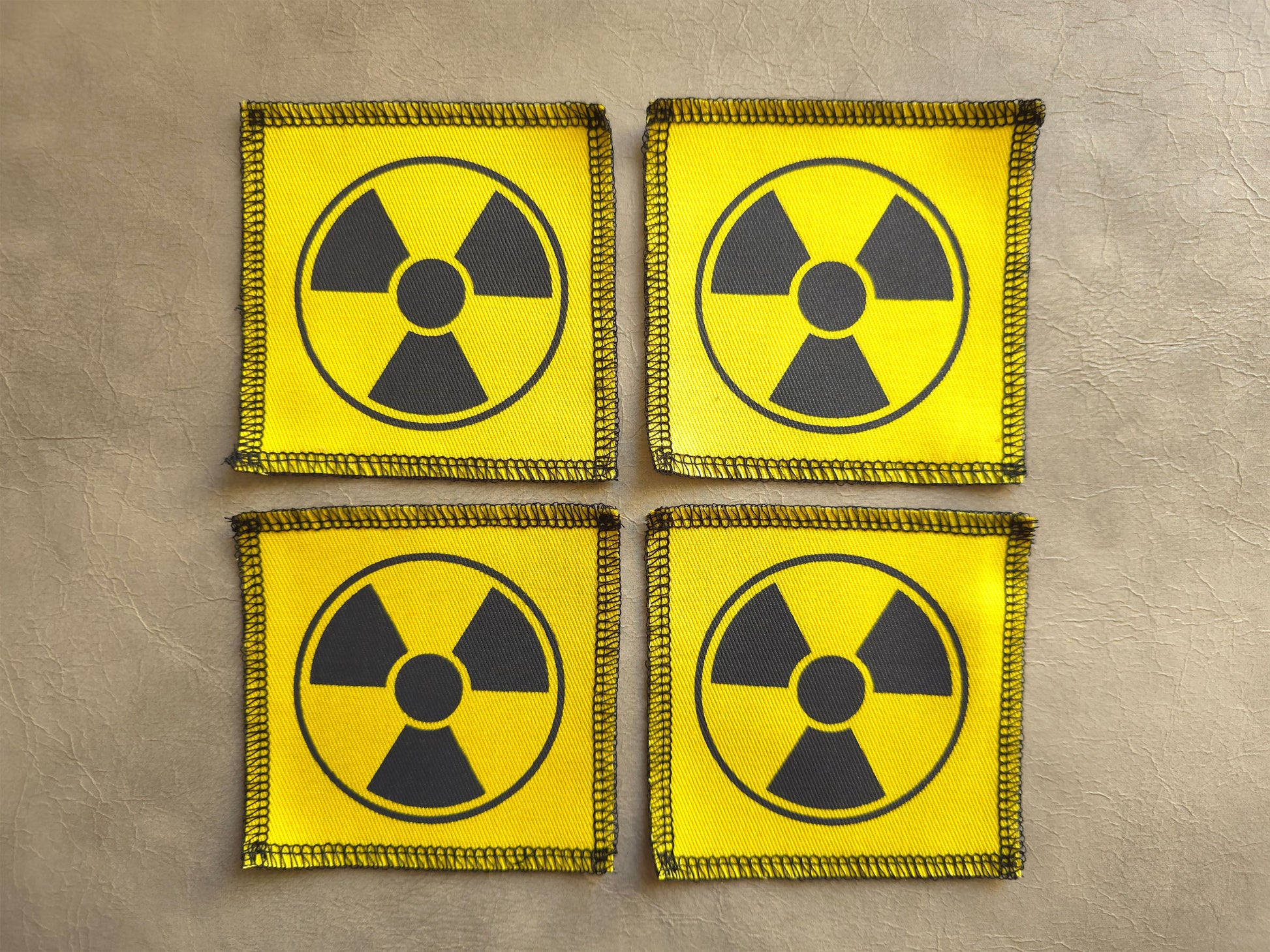 Set of yellow handmade screen printed radioactive symbol patches displayed together