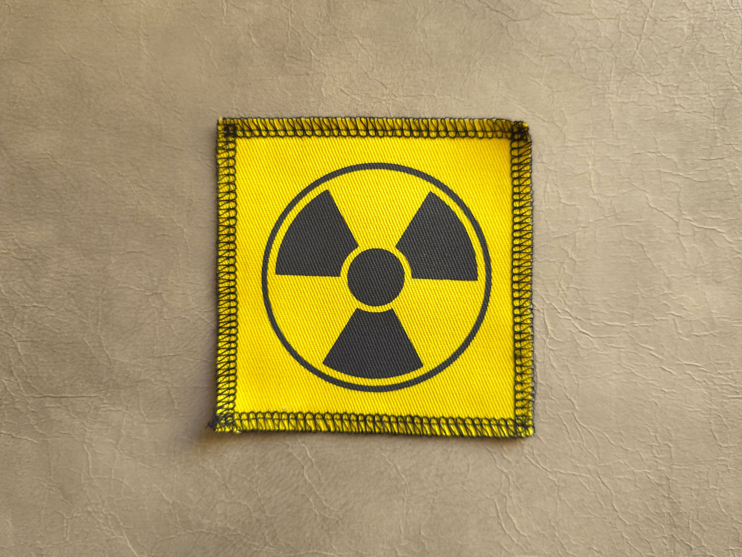 Yellow handmade screen printed radioactive symbol patch with bold graphic print