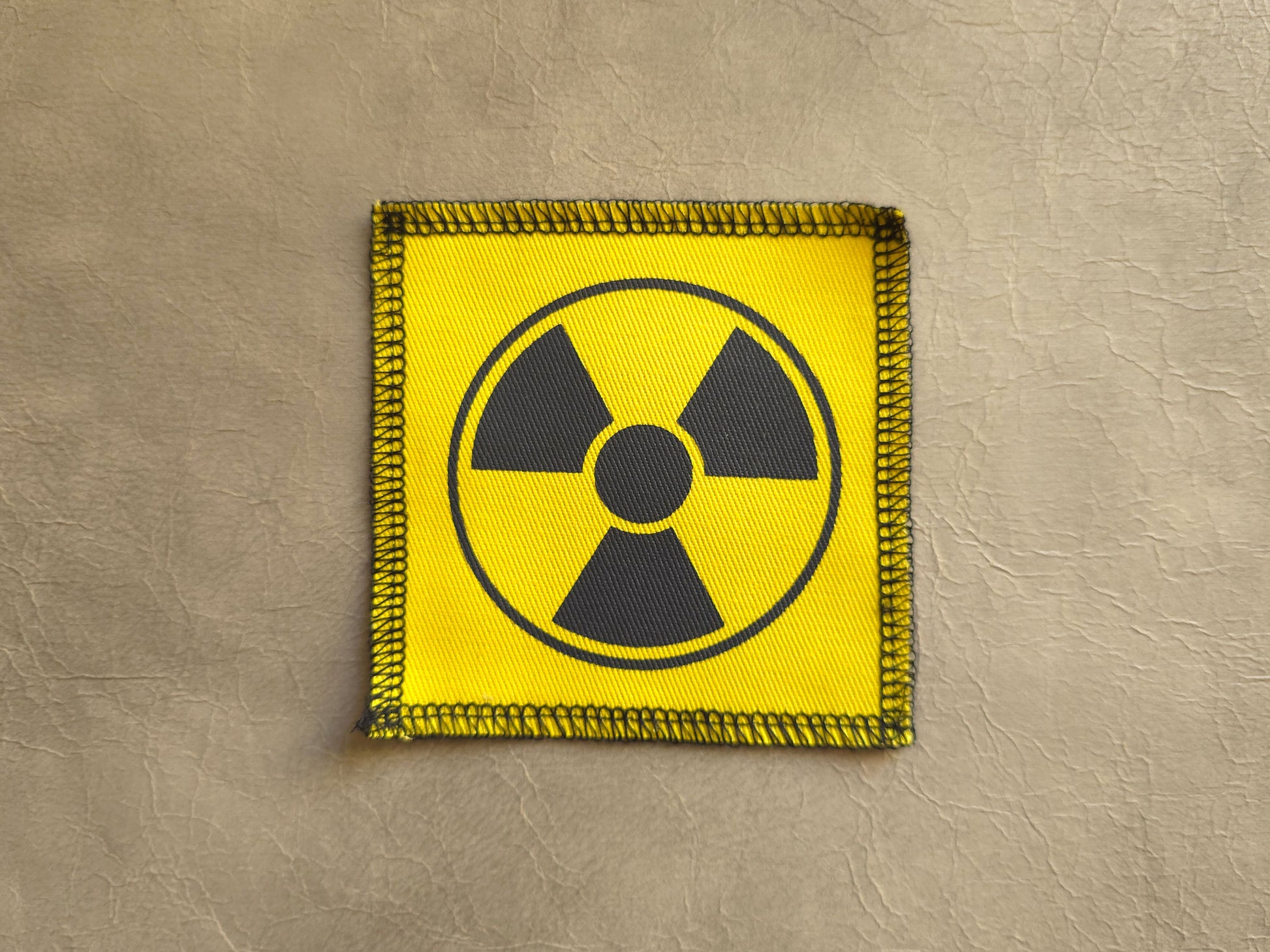 Yellow handmade screen printed radioactive symbol patch with bold graphic print