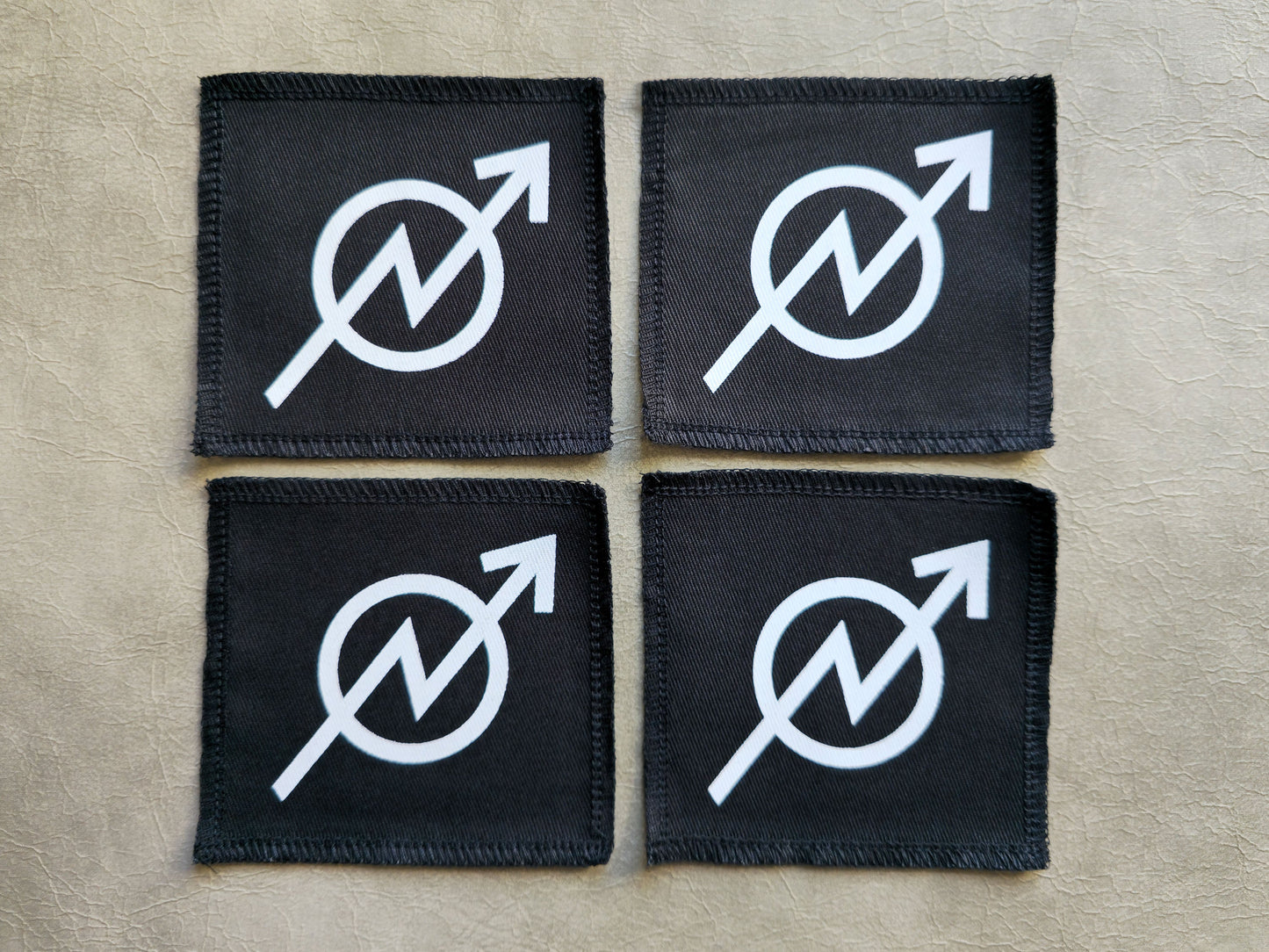 Black handmade screen printed squat symbol patches displayed together